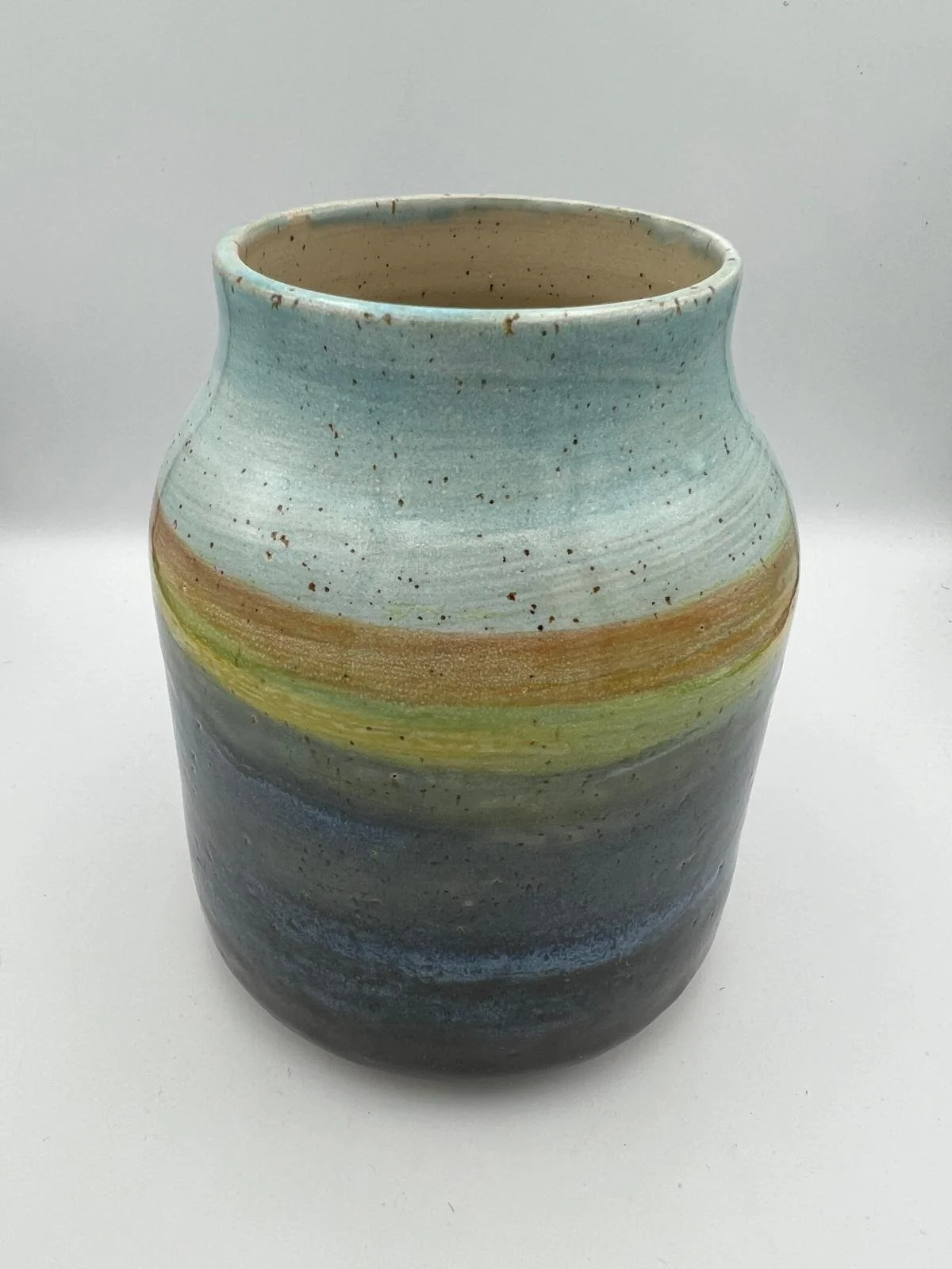 Potloodkleurige keramische vaas met een kleurrijke, gespreide patroon en een lichte, geruwde textuur.