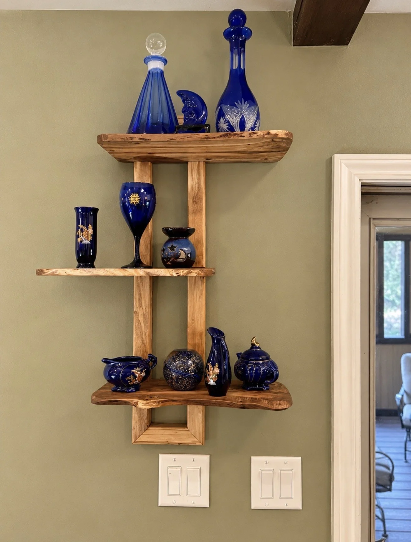 Completed Liberty Woodworks solid-wood wall shelves with blue glass displayed