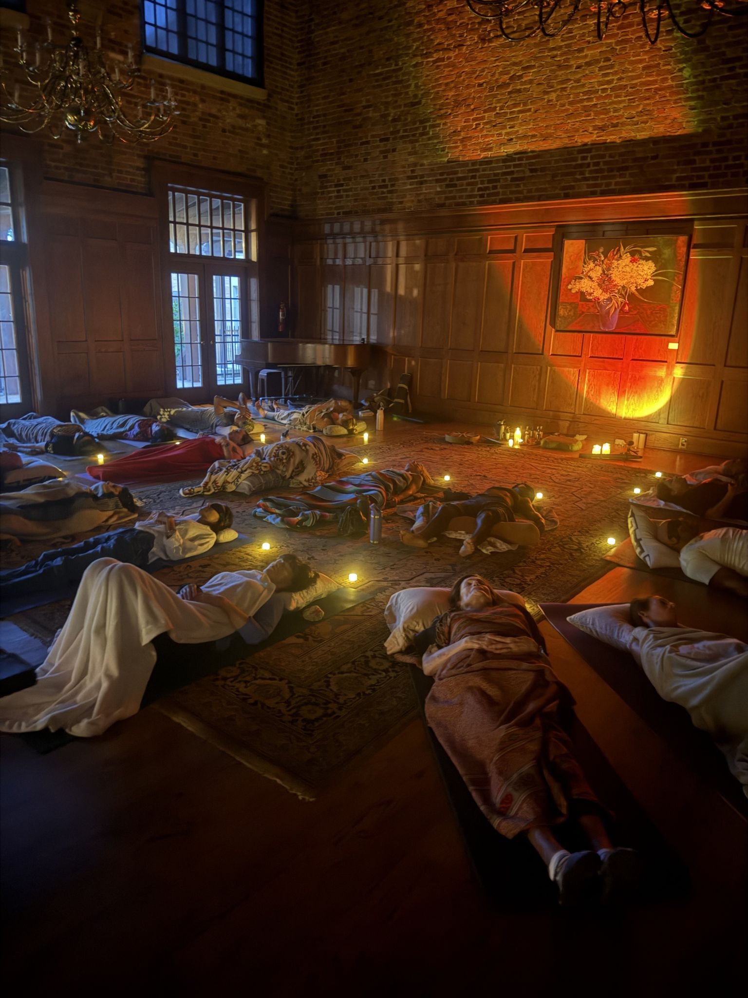 Room full of people laying down doing breathwork