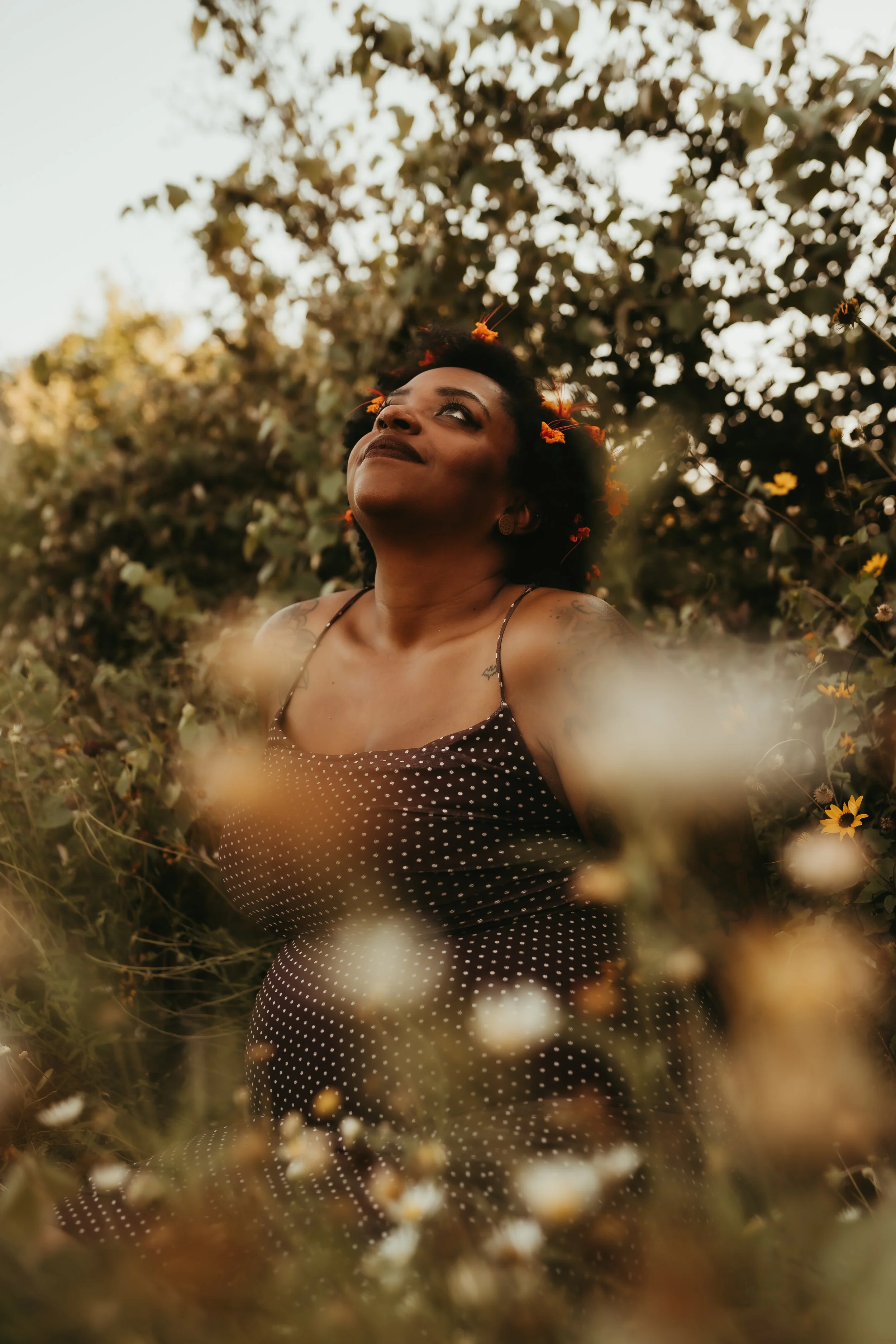a proud smiling black woman with flowers in her hair.jpg