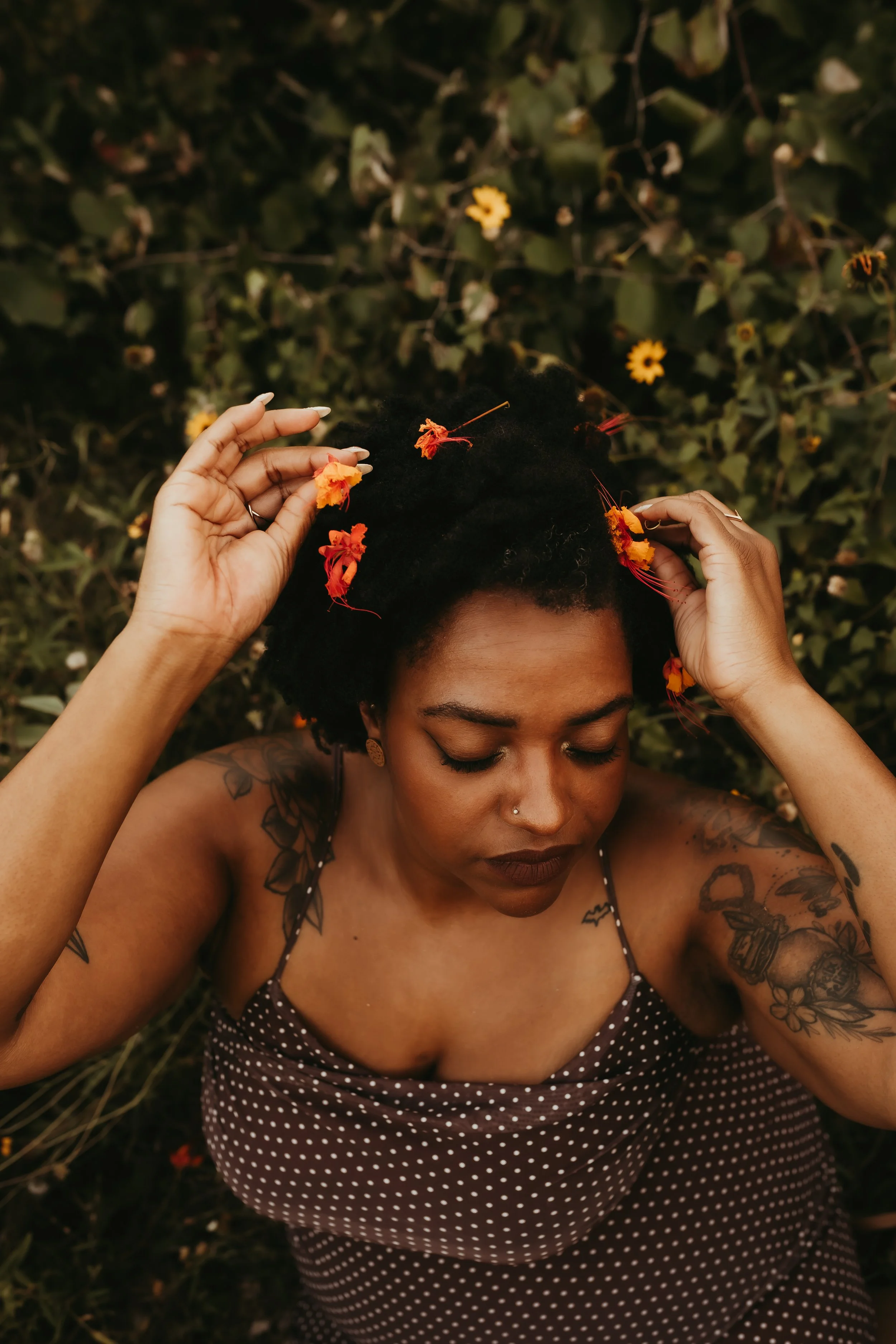 black woman holding orange flowers in her hair.jpg