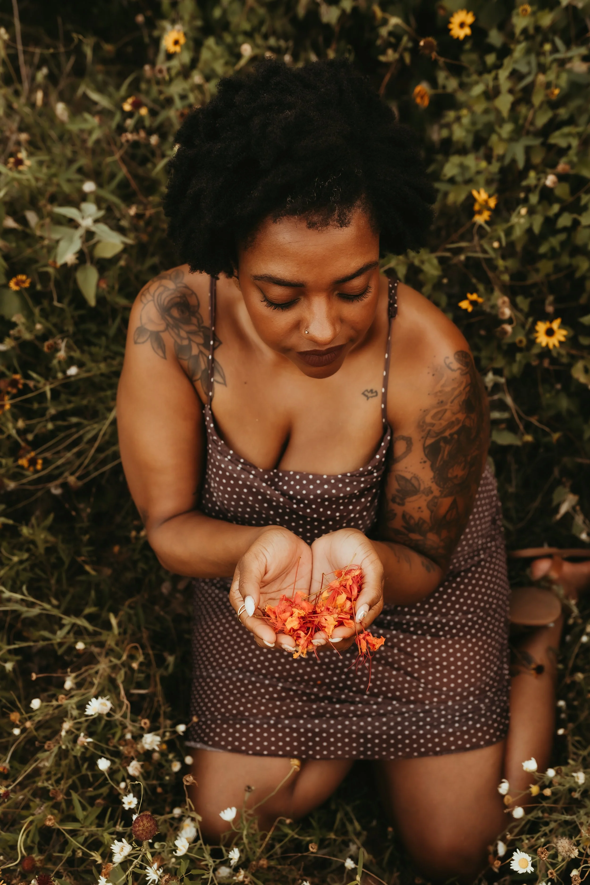 black woman holding flowers in a field.jpg