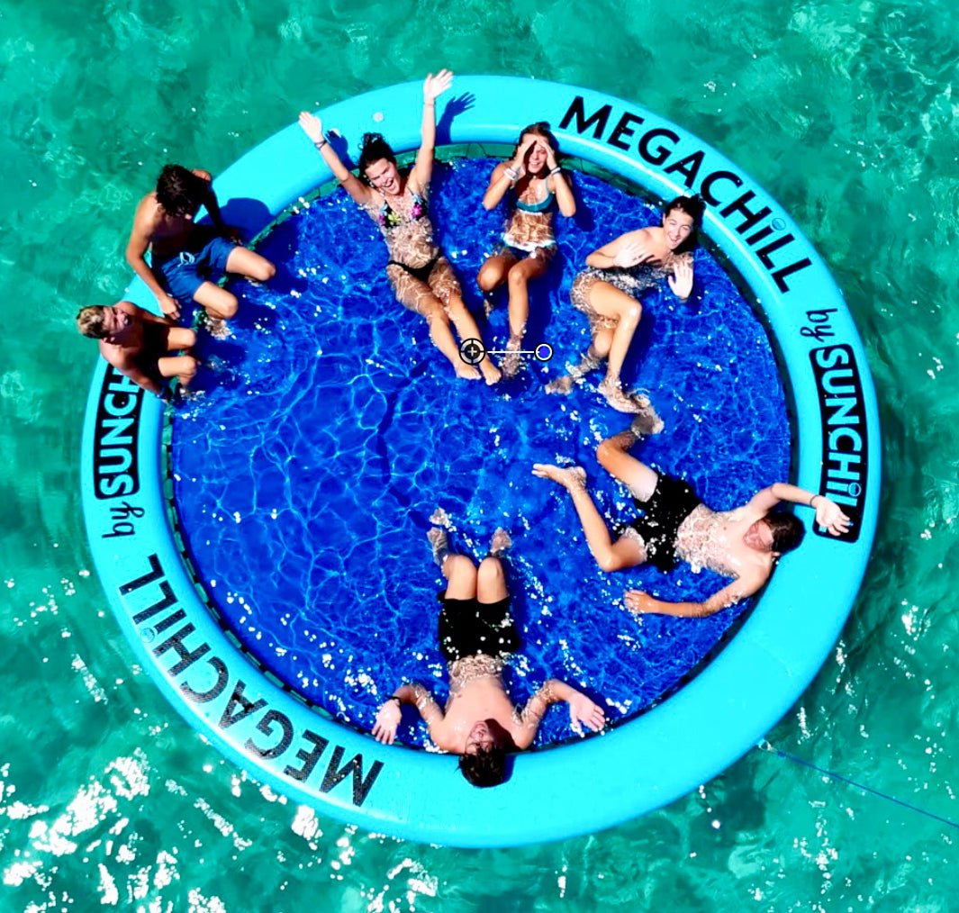 Group of children playing on a large, inflatable, circular water toy labeled 'Megachill by Sunachill' floating on a pool.