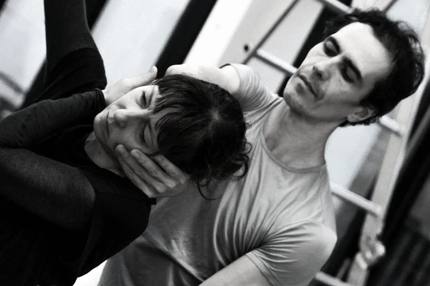 A moment of physical confrontation between a man and a woman in a gym setting, with the woman in distress and the man holding her head.