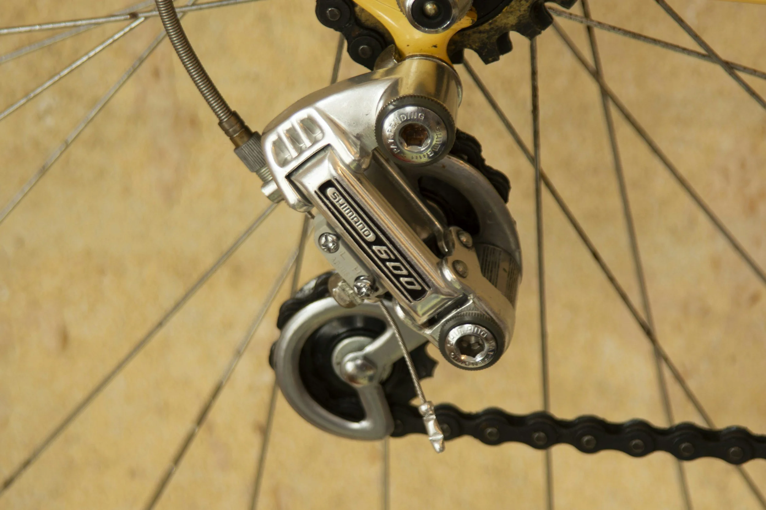 Close-up of a Shimano Dura-Ace 7000 rear derailleur and part of the cassette and chain on a bicycle.