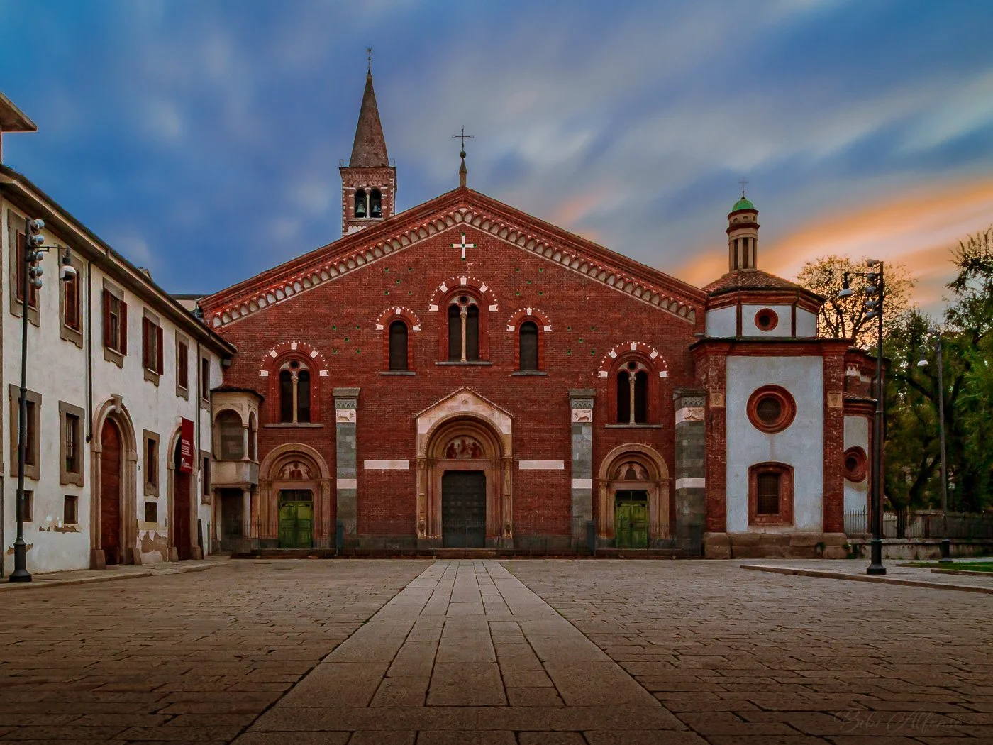 50-second sunrise exposure over Basilica di Sant’Eustorgio in Milan, with streaky clouds and warm early-morning light.