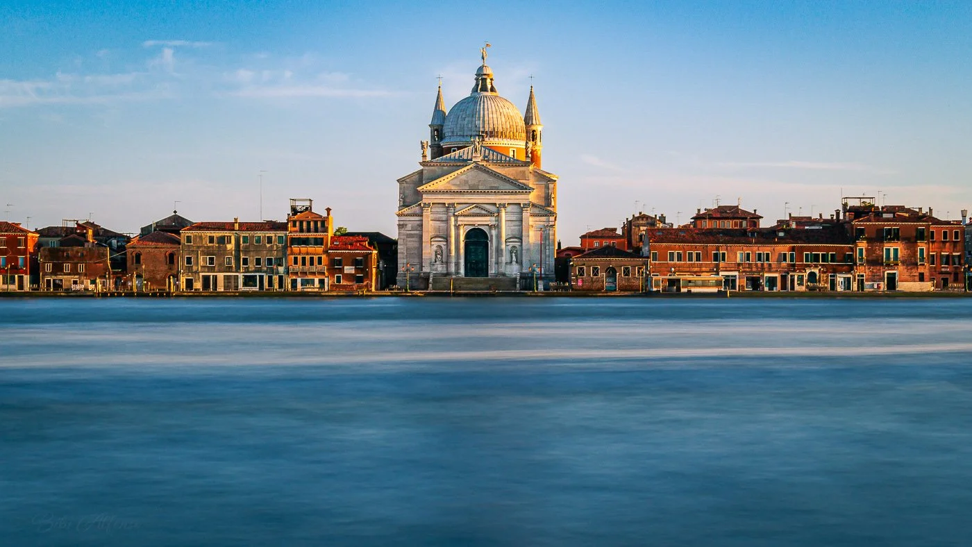 The Basilica del Redentore basks in the stillness of a Venetian afternoon, its white façade gently kissed by daylight. Across the Giudecca Canal, silence lingers — timeless, weightless, and serene.