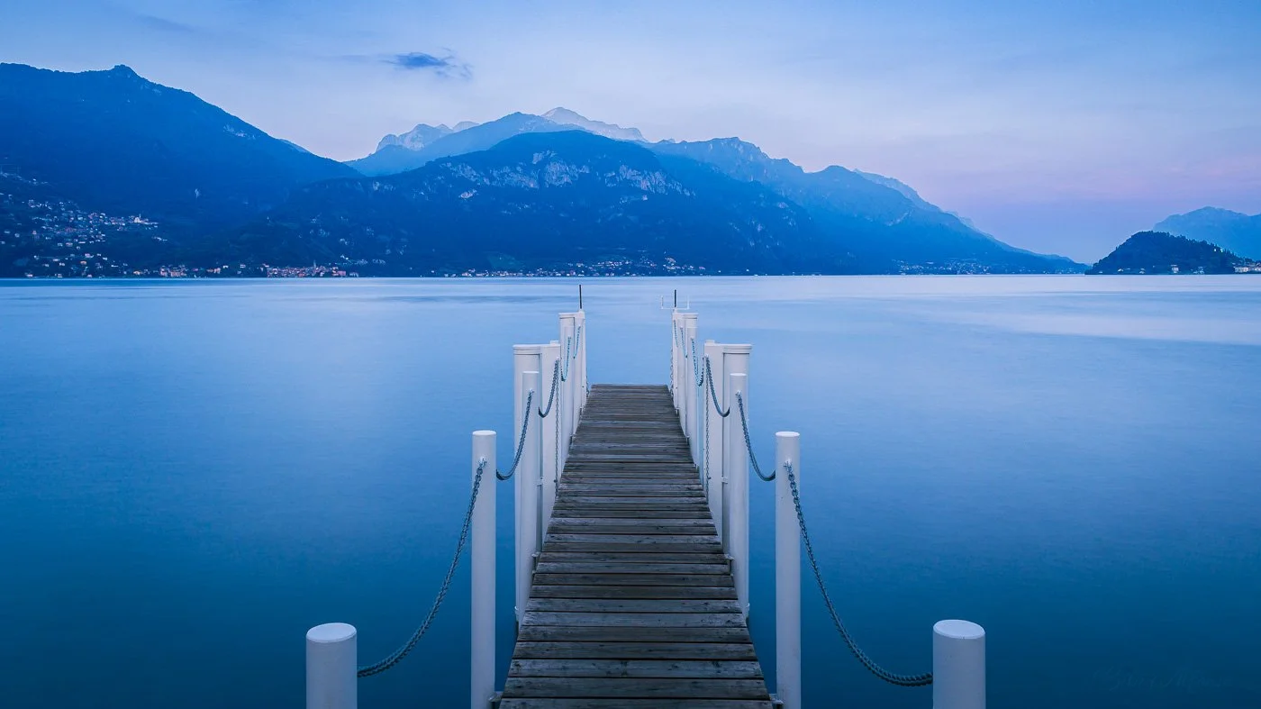 Long exposure from Menaggio on Lake Como, with gentle blue tones and still waters evoking deep quiet and reflection.