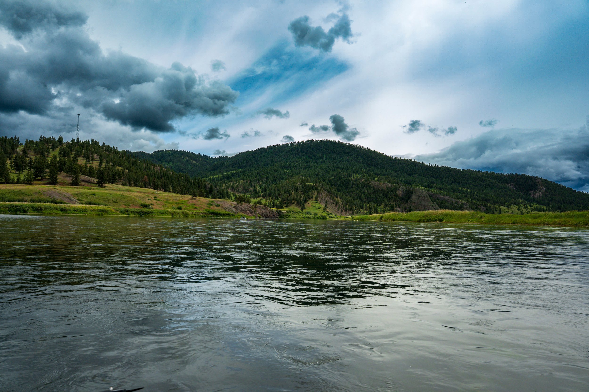Light breaking over green hills and water, Montana