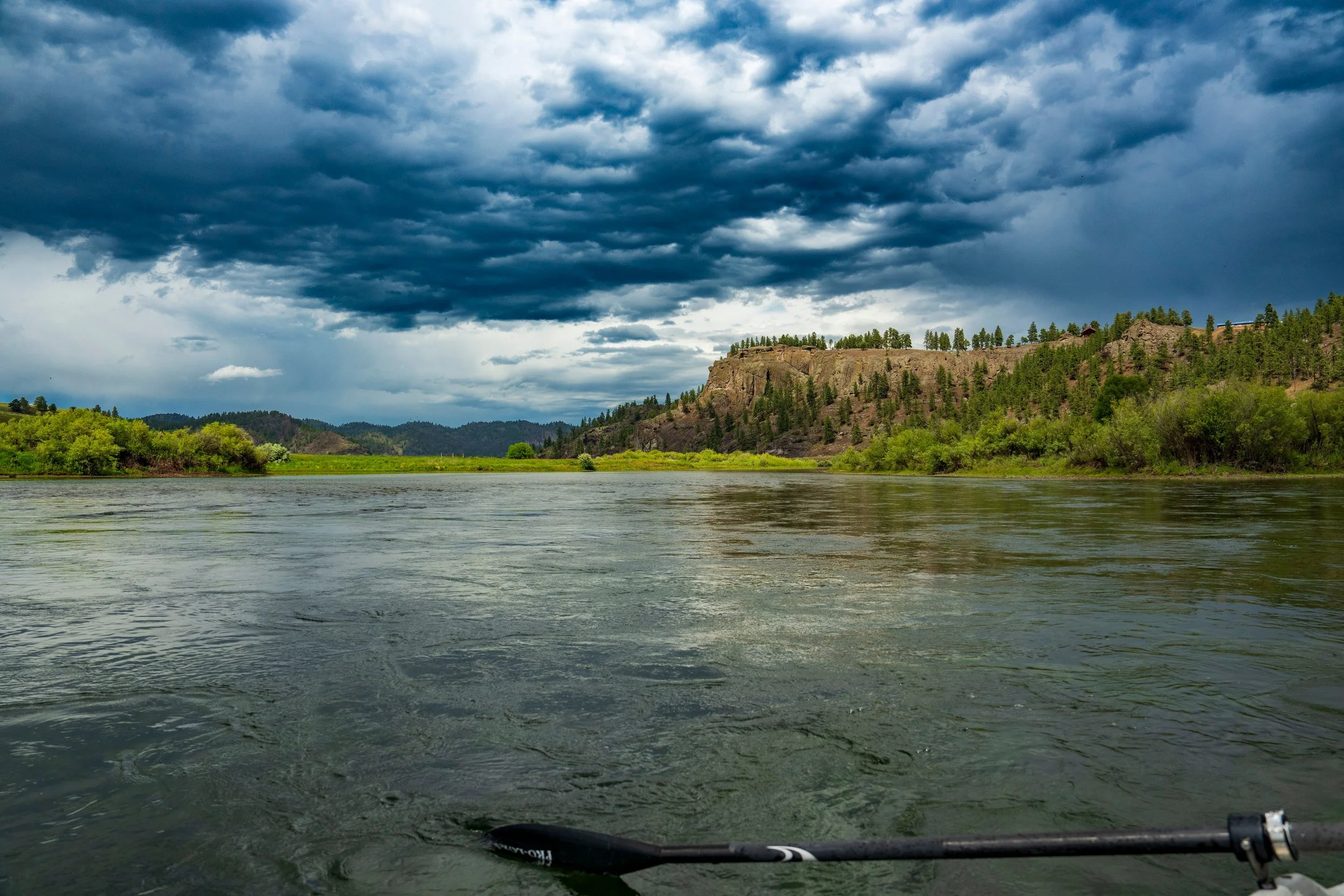 Oar tip above the river under heavy clouds, Montana