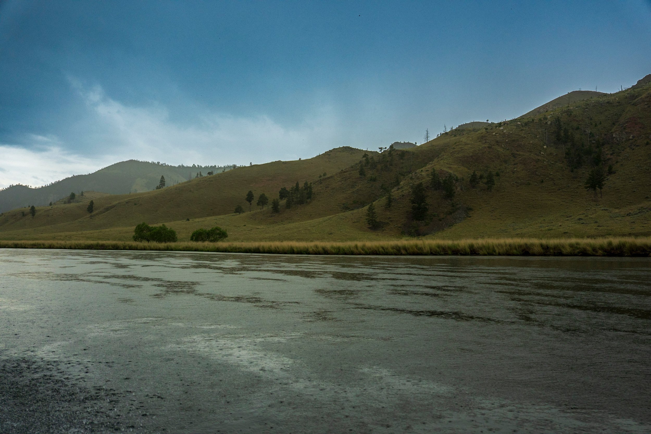 Grassy hills along a quiet river, Montana