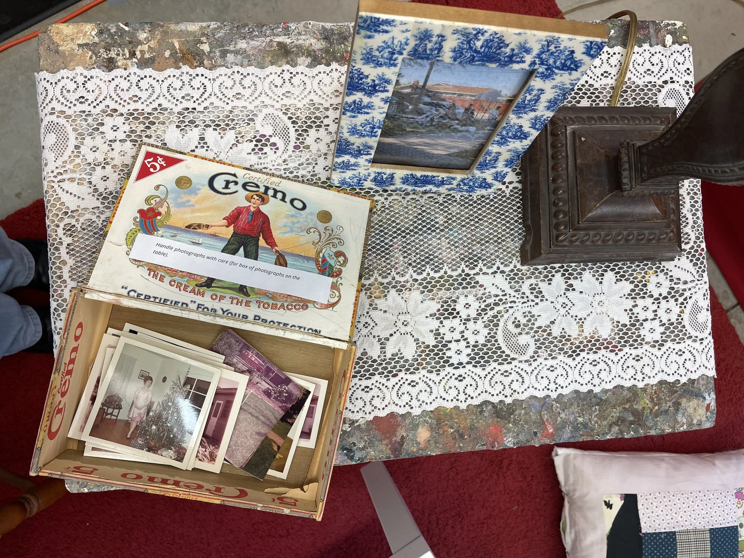 To Sell A Home, 2025, installation details - doily, Cremo cigar box, original printed photographs from the Home