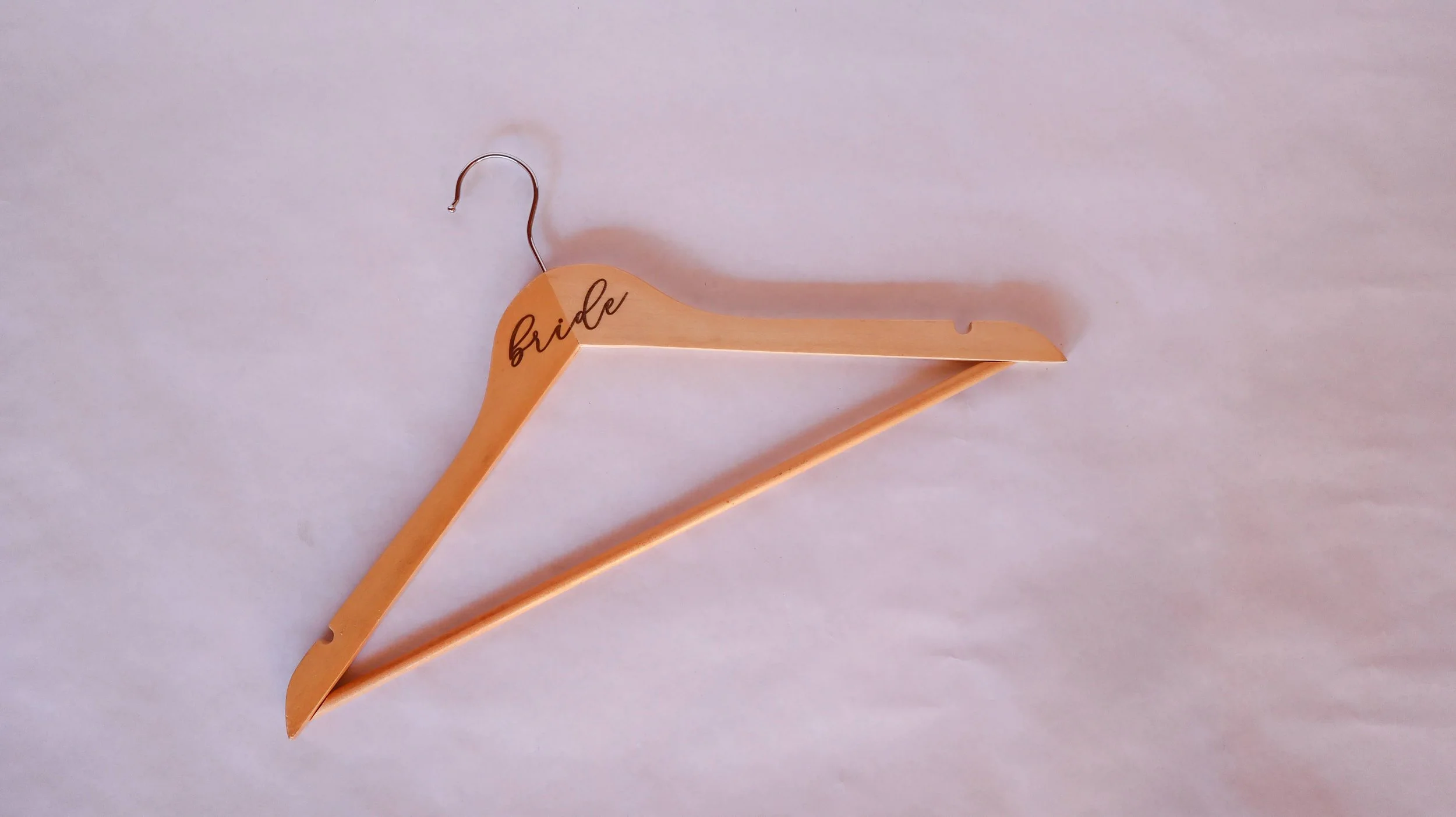 Wooden dress hanger engraved with the word bride, available to brides who have their Colorado wedding planned by JayBird Weddings and Events