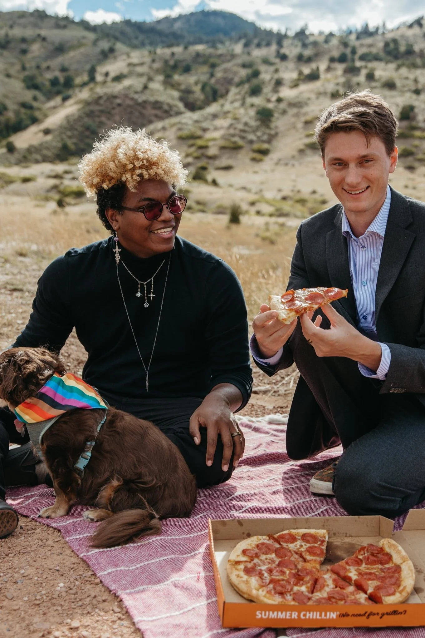 Two grooms eating pizza on their wedding day, outside in the Colorado mountains, planned by JayBird Weddings and Events