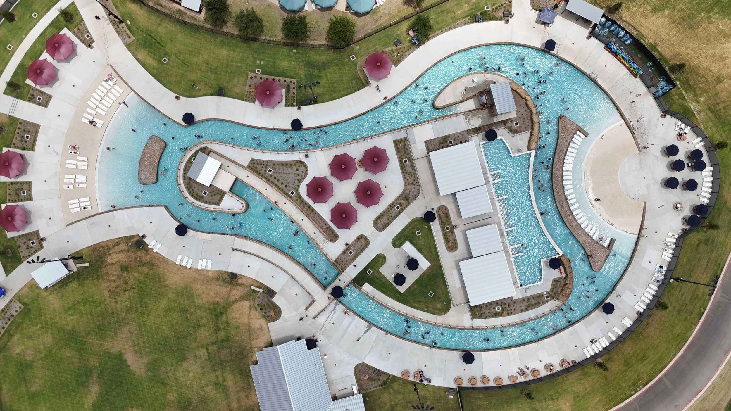 Aerial shot of a water park in texas featuring artificial rock around the interior of the lazy river.