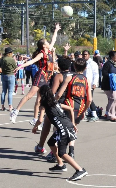 Youth playing outdoor netball game on a sunny day