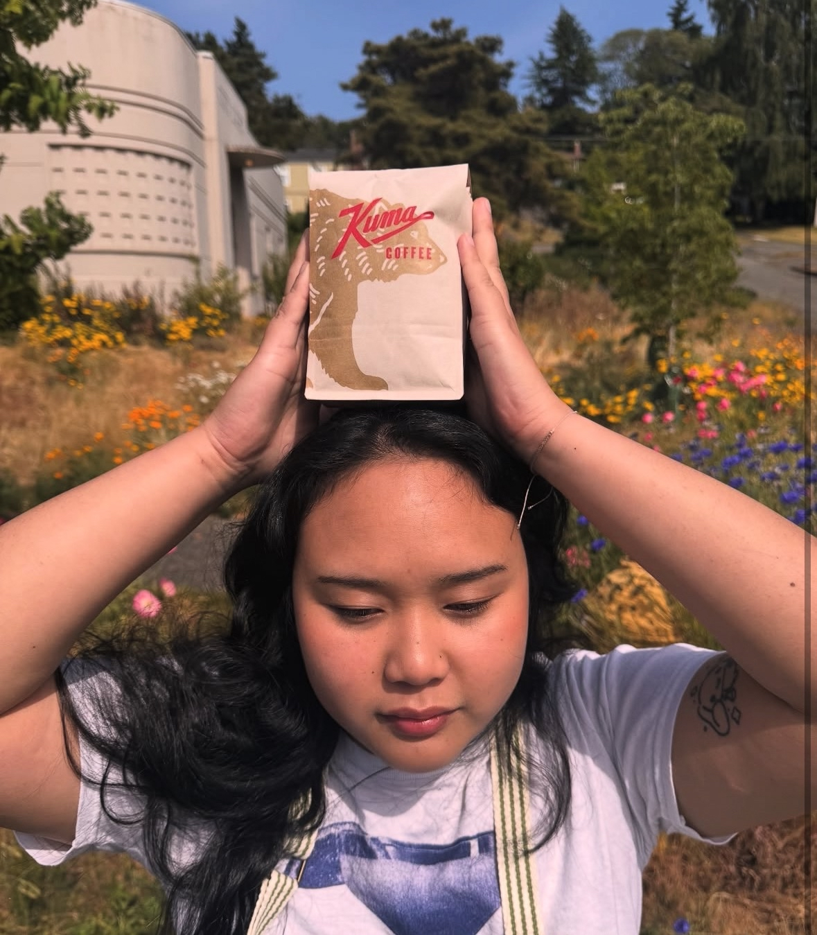 Young Thai business owner Emily Sirisup taking a picture with her single origin coffee beans from Thailand, roasted by Kuma Coffee in Seattle.