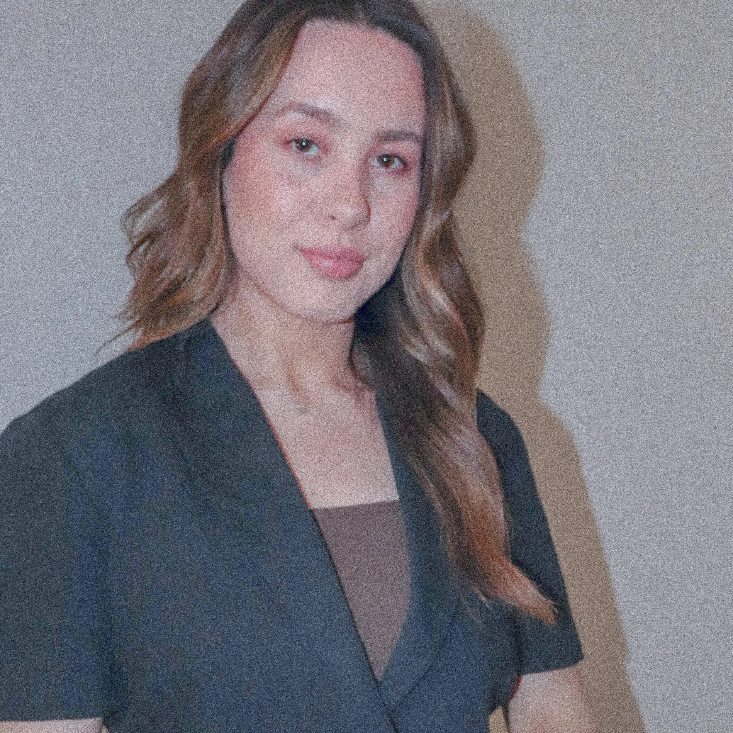 Kaitlyn Boyer Profile Photo. Kaitlyn is off centre to the left of frame, facing the camera, with a closed smile. She is wearing a black short sleeve blazer.