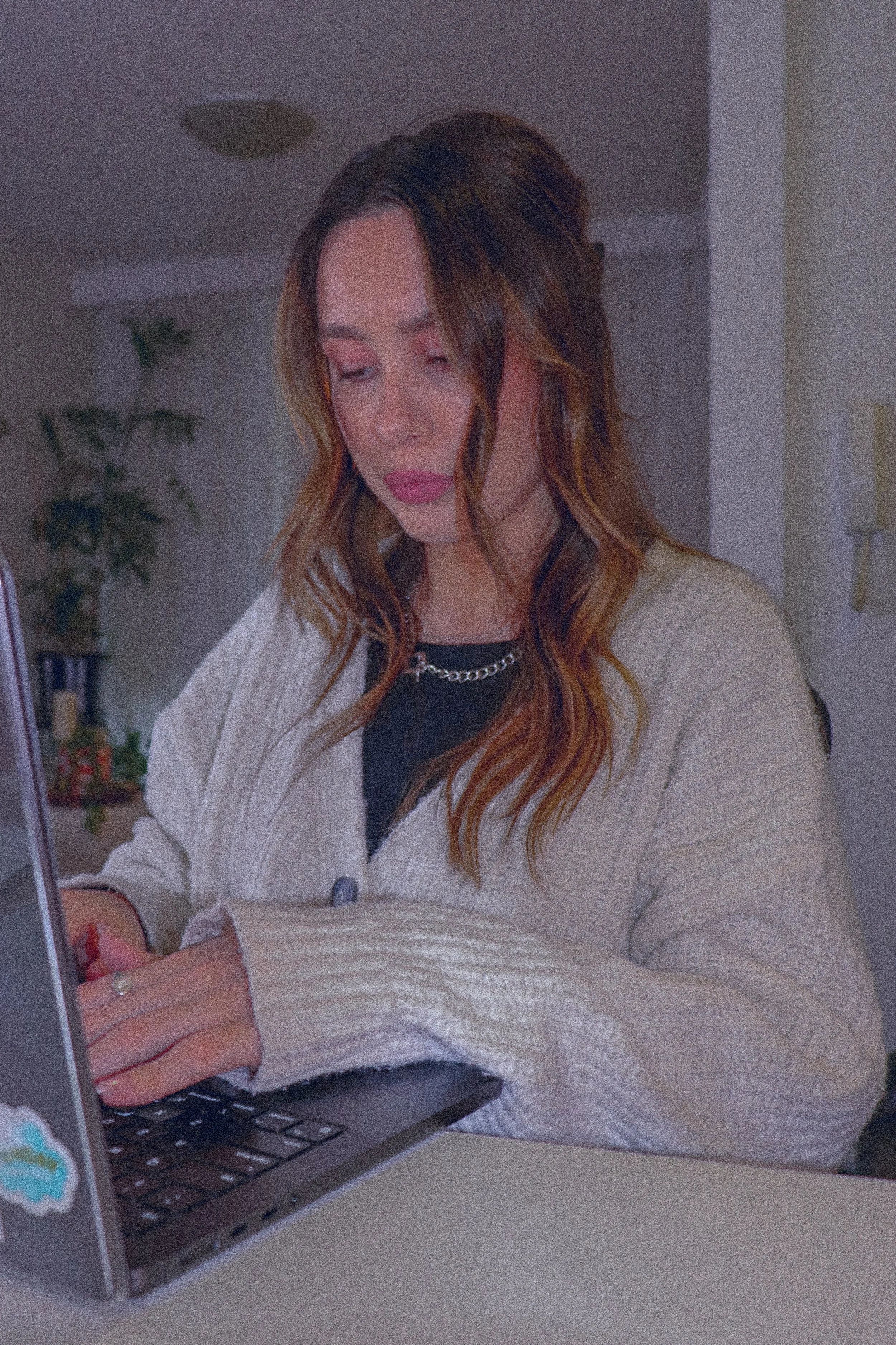 This photo shows Kaitlyn working at a desk with her laptop in front and hands on the keyboard.