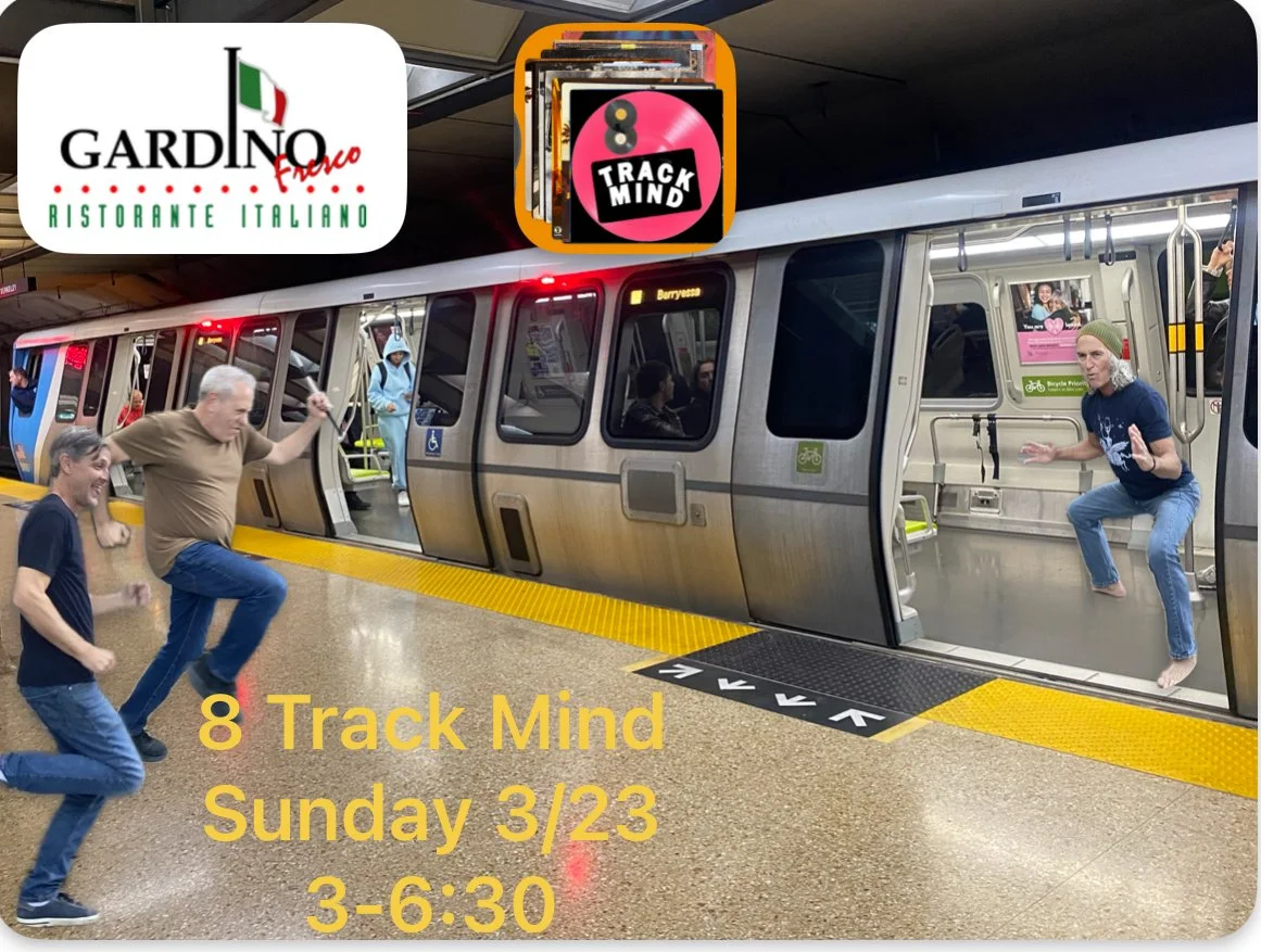 Four people are playfully posing as if they are standing on a subway train platform. Two are pretending to be in the train, while the other two are pretending to be on the platform. The subway train is at a station with its doors open. Text on the im