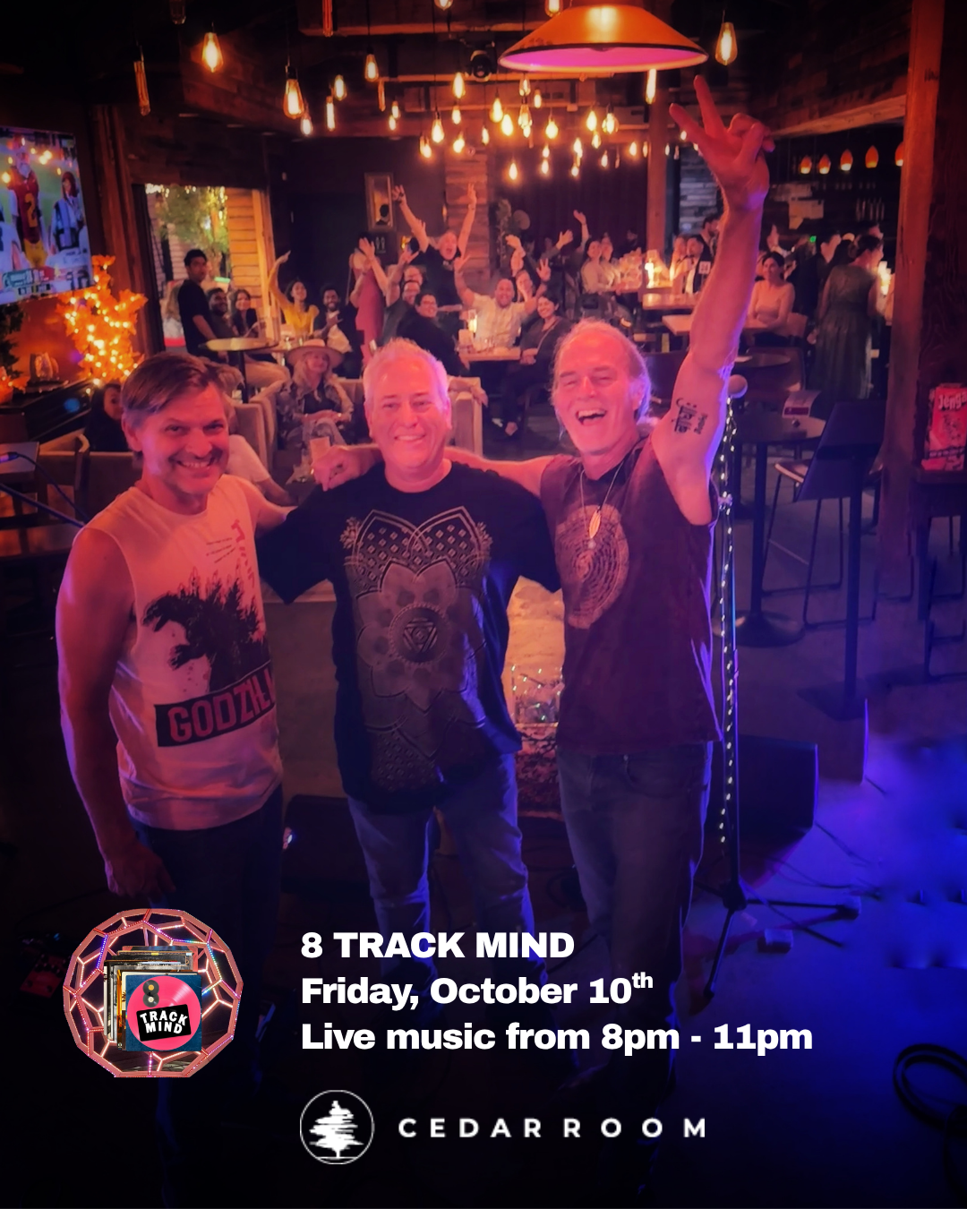 Three men on stage at a live music event, smiling and posing with one raising his arm in front of a lively audience in a dimly lit, cozy venue with wooden decor and warm lighting. Text overlay announces event details for 8 Track Mind at Cedar Room on