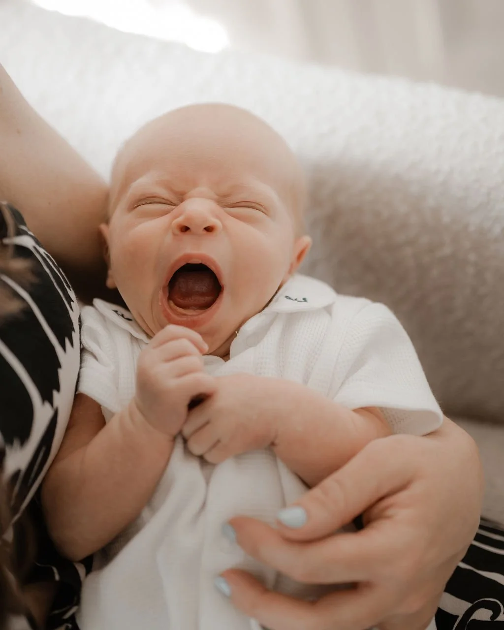 newborn-baby-yawning-while-being-newborn-photo-shoot.jpg