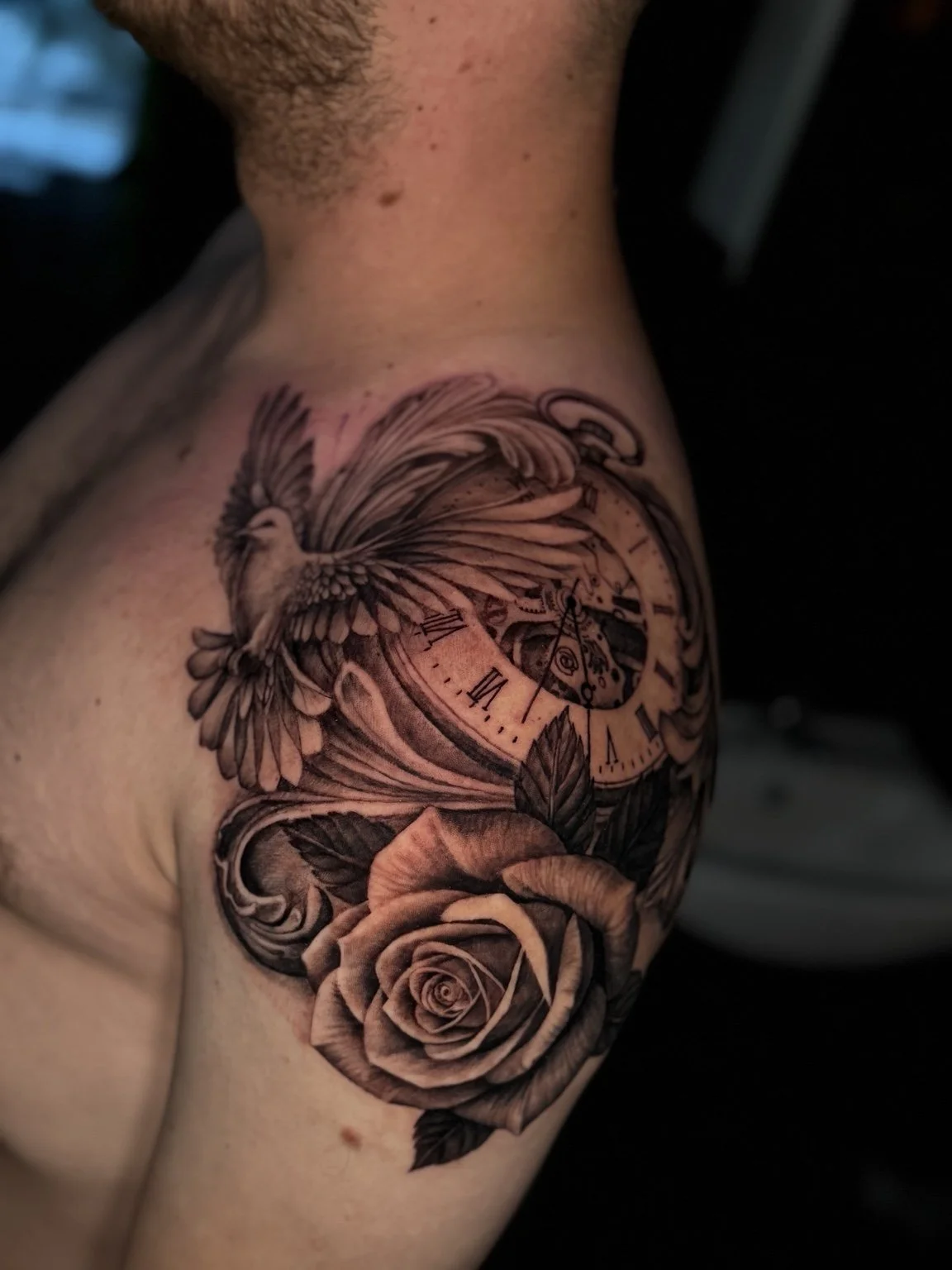 Black and grey bird, clock and rose shoulder tattoo by Alina Horobets, Bournemouth