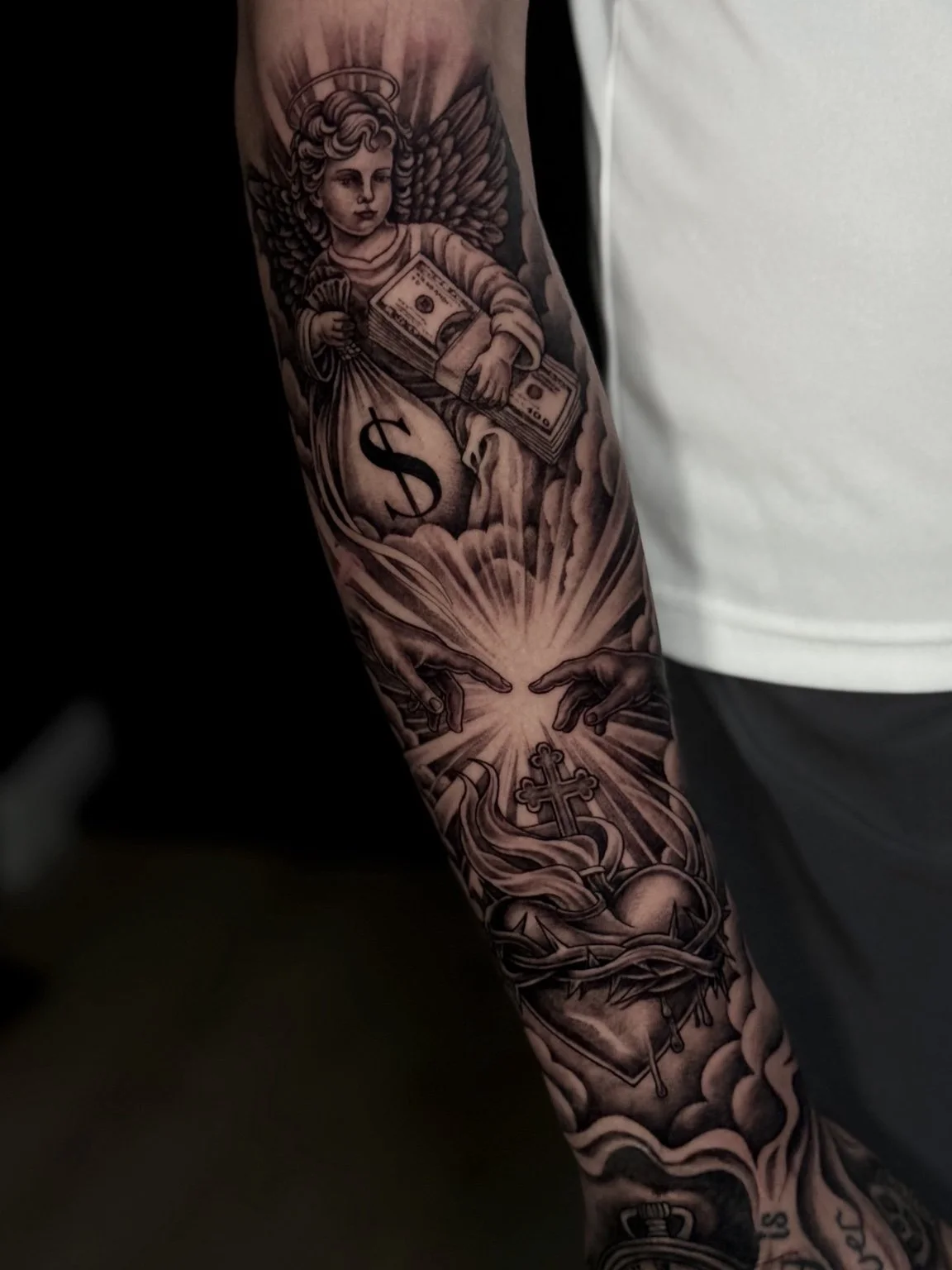 Black and grey angel, hands and sacred heart sleeve tattoo by Alina Horobets, Bournemouth