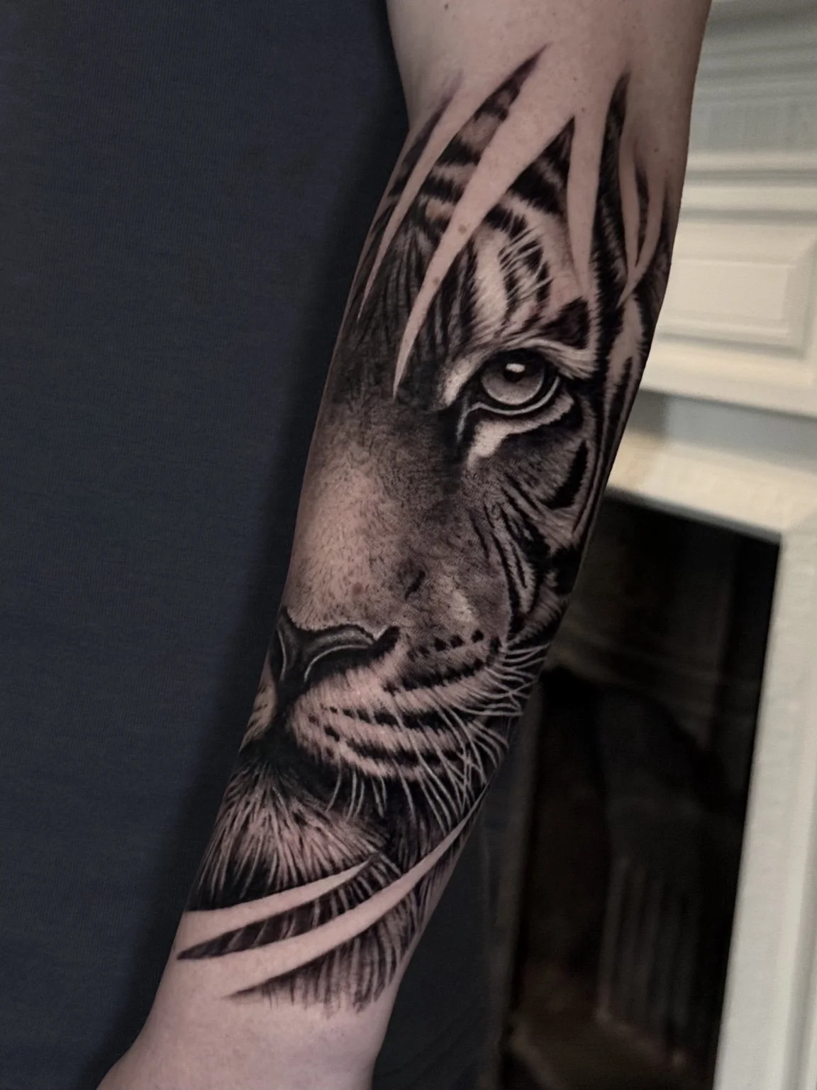 Black and grey realistic tiger forearm tattoo by Alina Horobets, Bournemouth