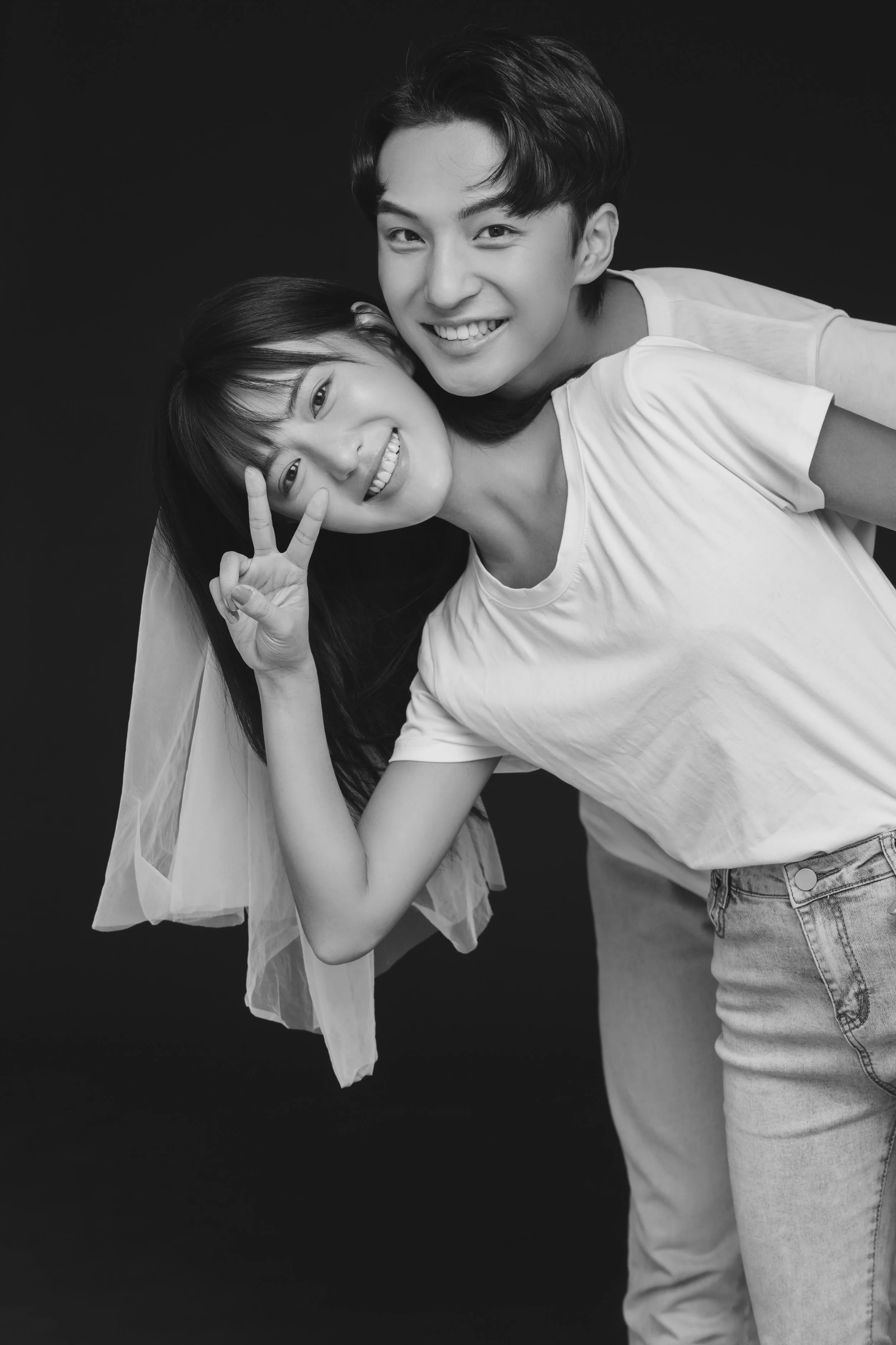 Black and white photo of a young couple posing in a photo studio for a pre-wedding photoshoot