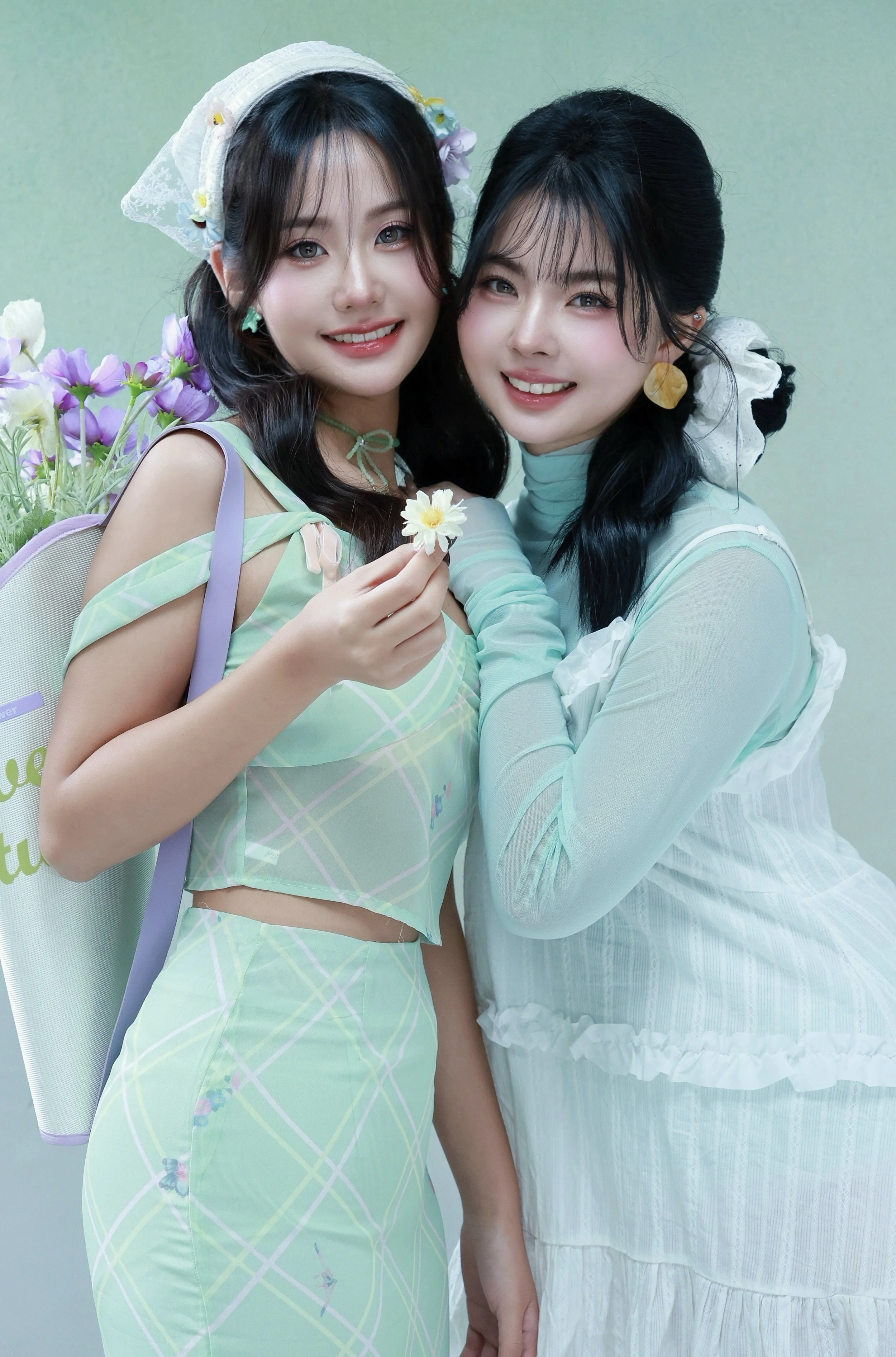 Two female friends smiling at the camera in studio photoshoot spring fresh floral mint green theme
