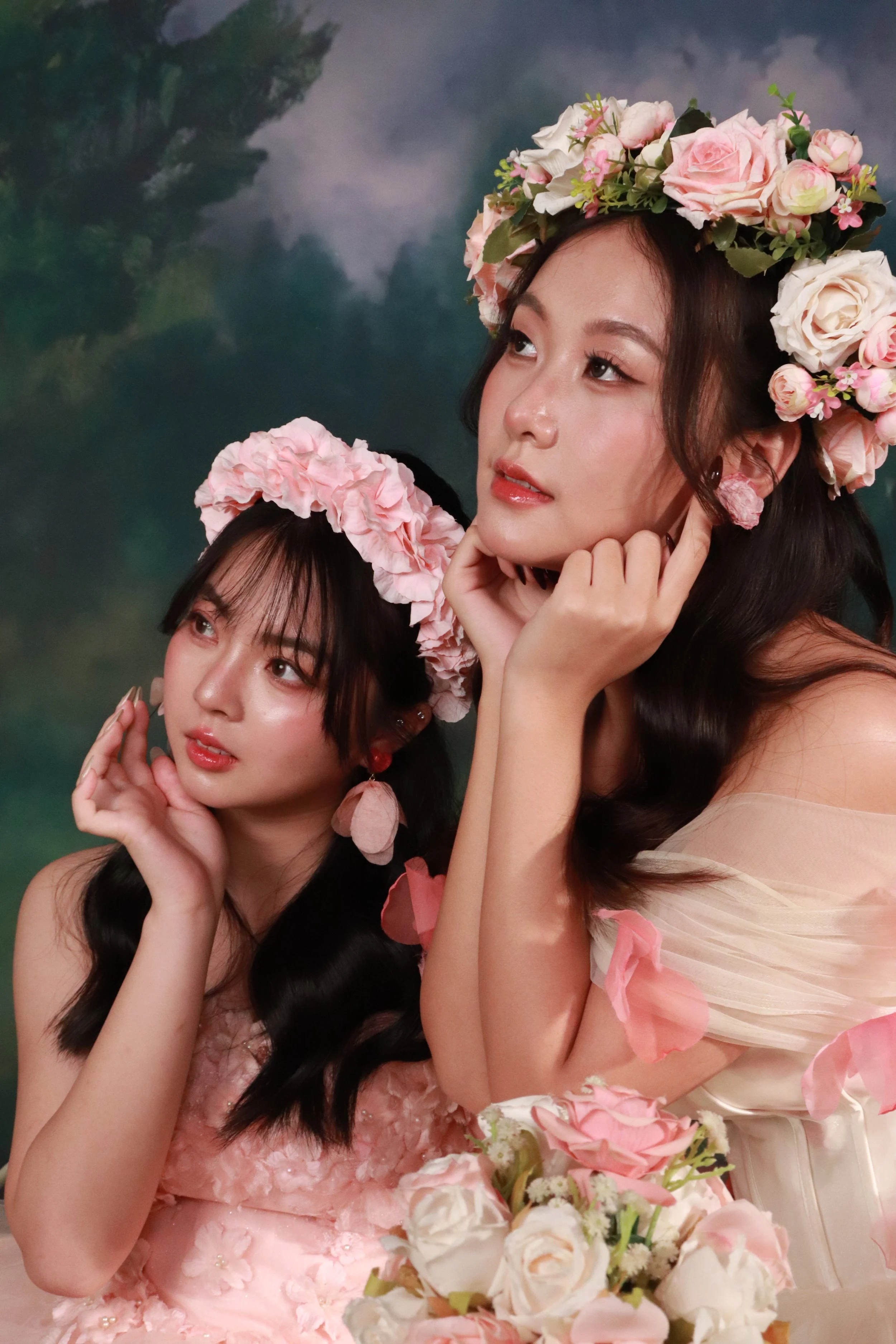 Two female friends in pink fantasy princess dresses looking away from the camera candidly