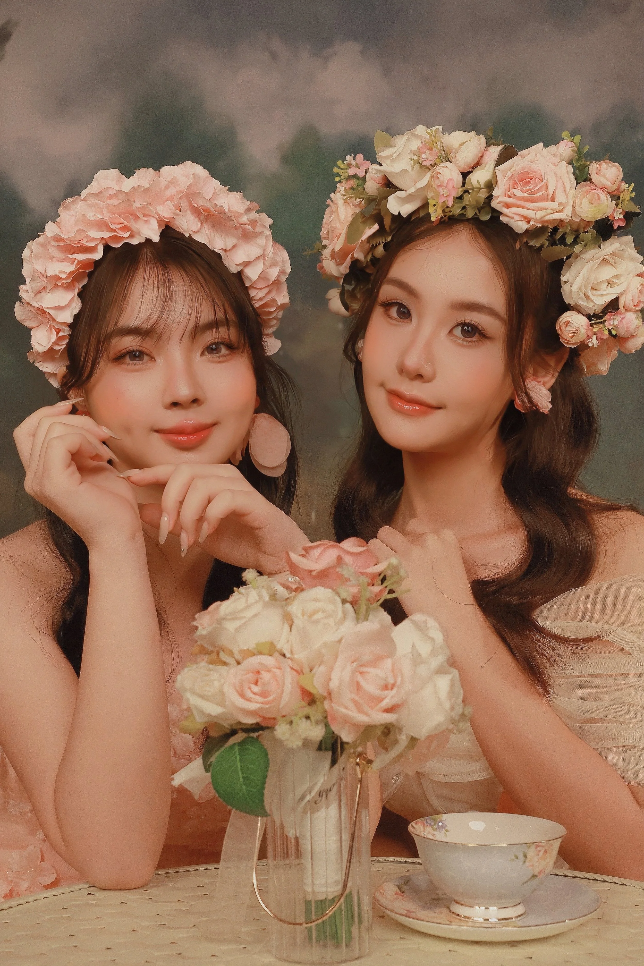 Two females wearing pink rose flower crowns posing in studio photoshoot