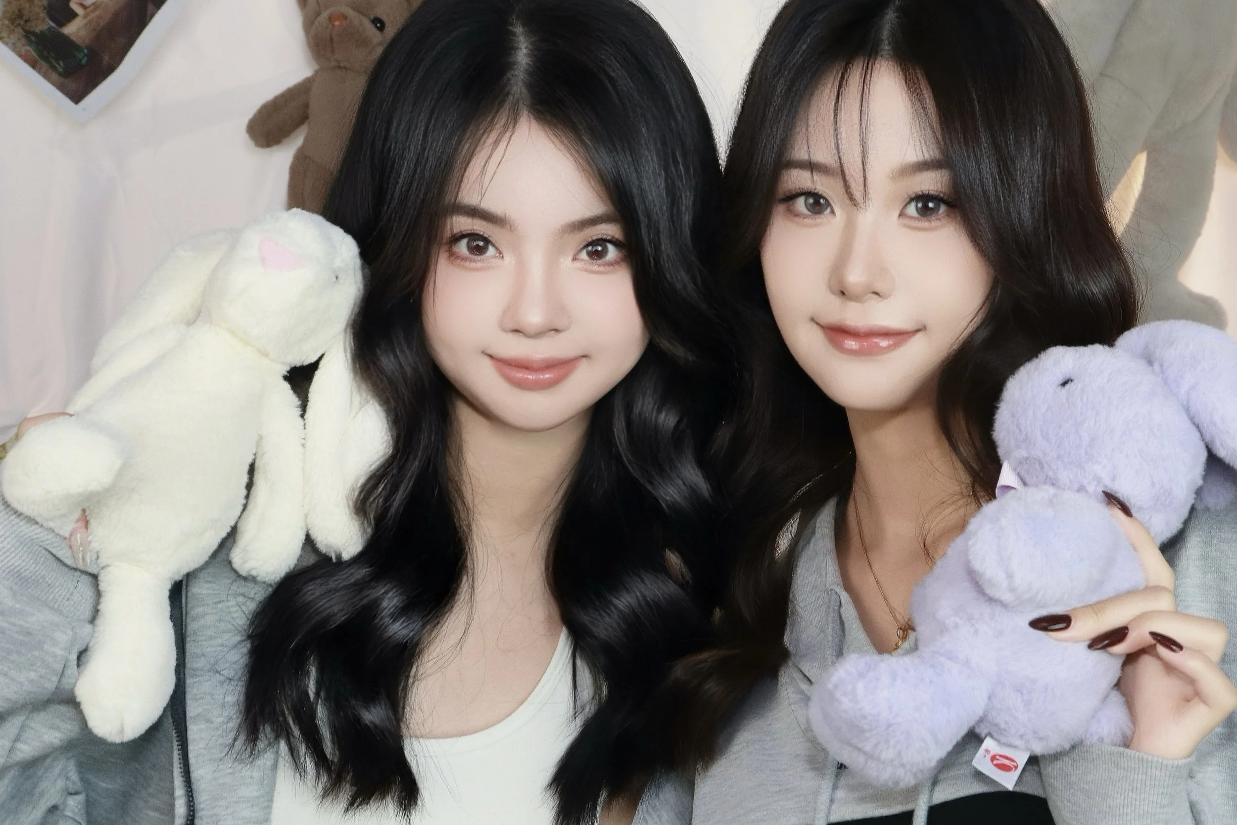 Two female friends posing together in a cozy photoshoot with bunny teddy bears and plush