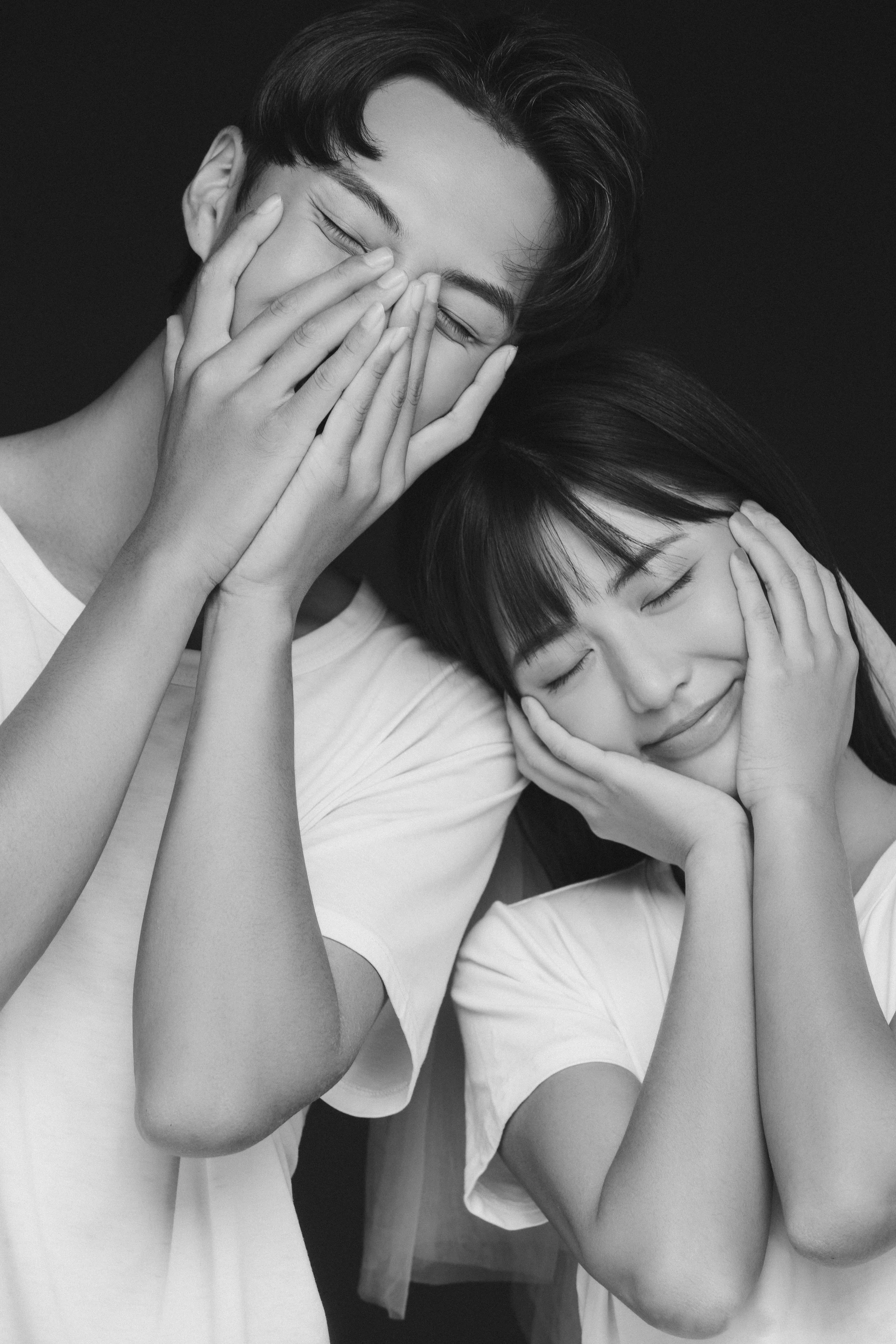 Monochromatic photo of a young couple posing cutely in a photo studio