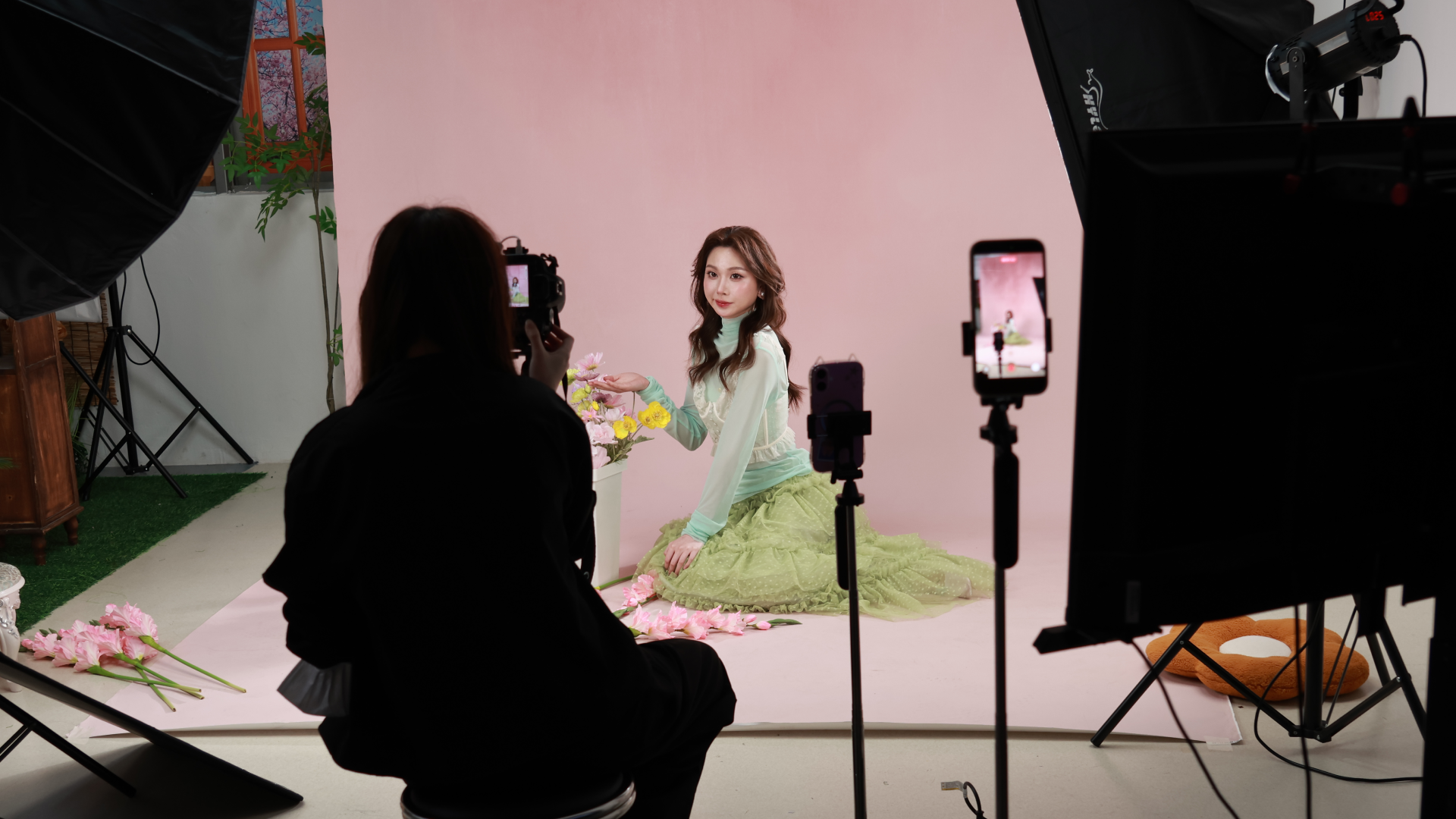 girl posing in a photo studio for korean style photoshoot pink background