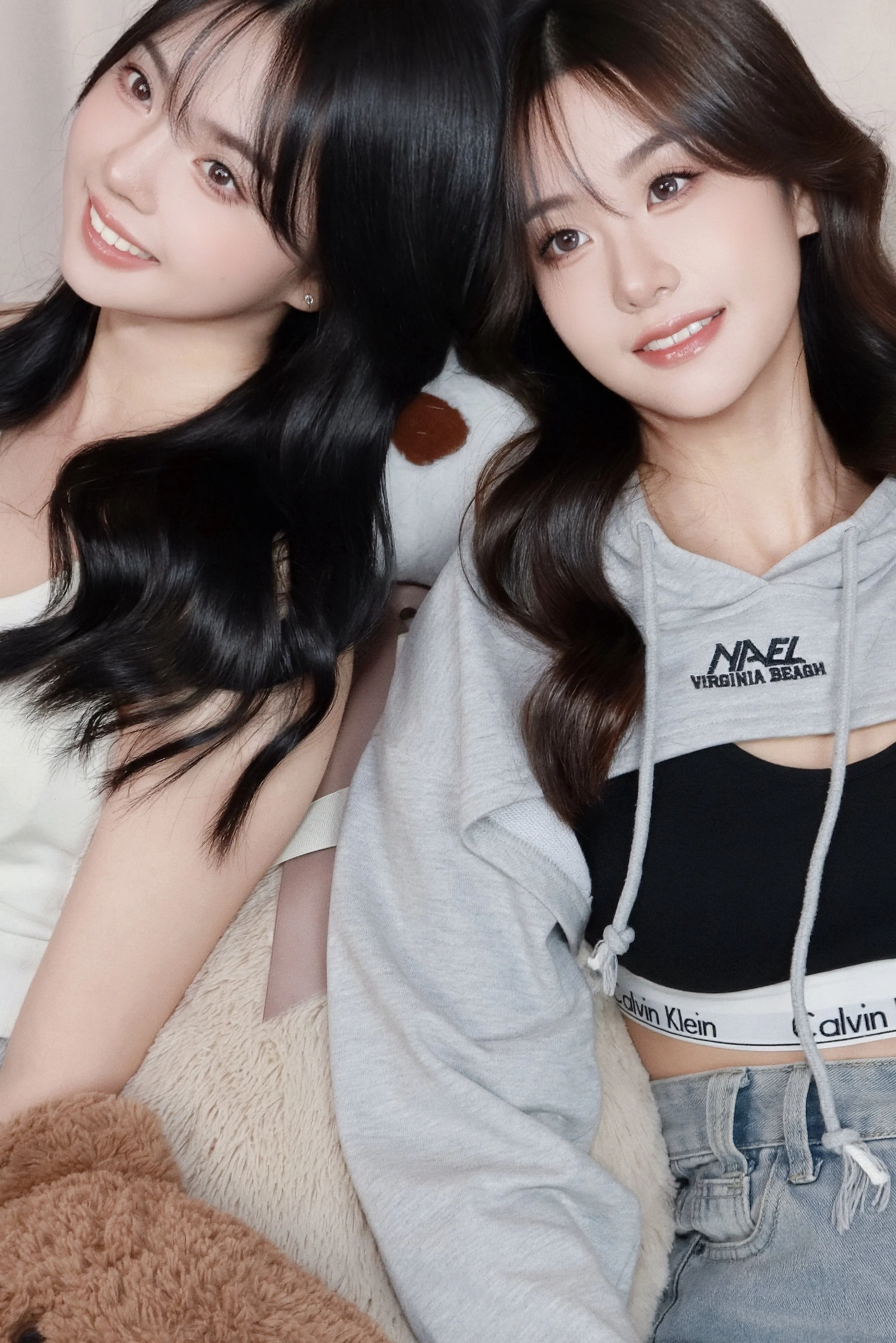 Two female friends leaning heads against each other in cozy setting