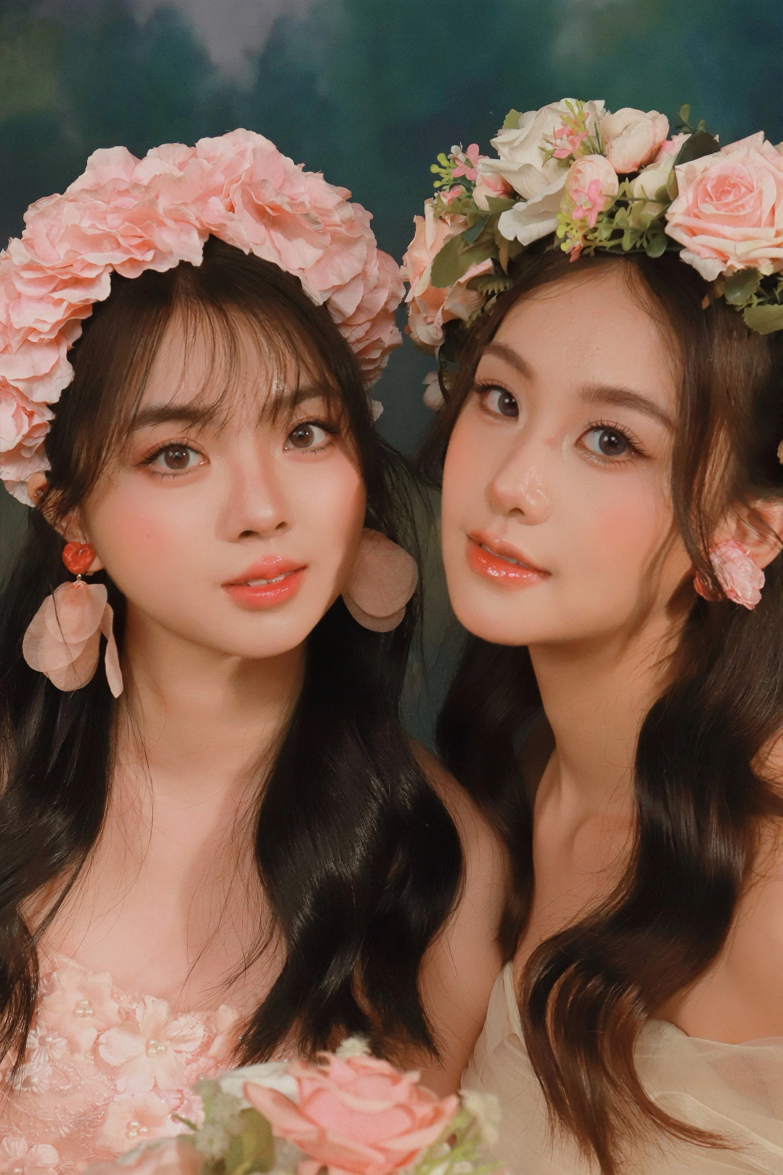 Close-up of two female friends posing in pink rose flower crowns