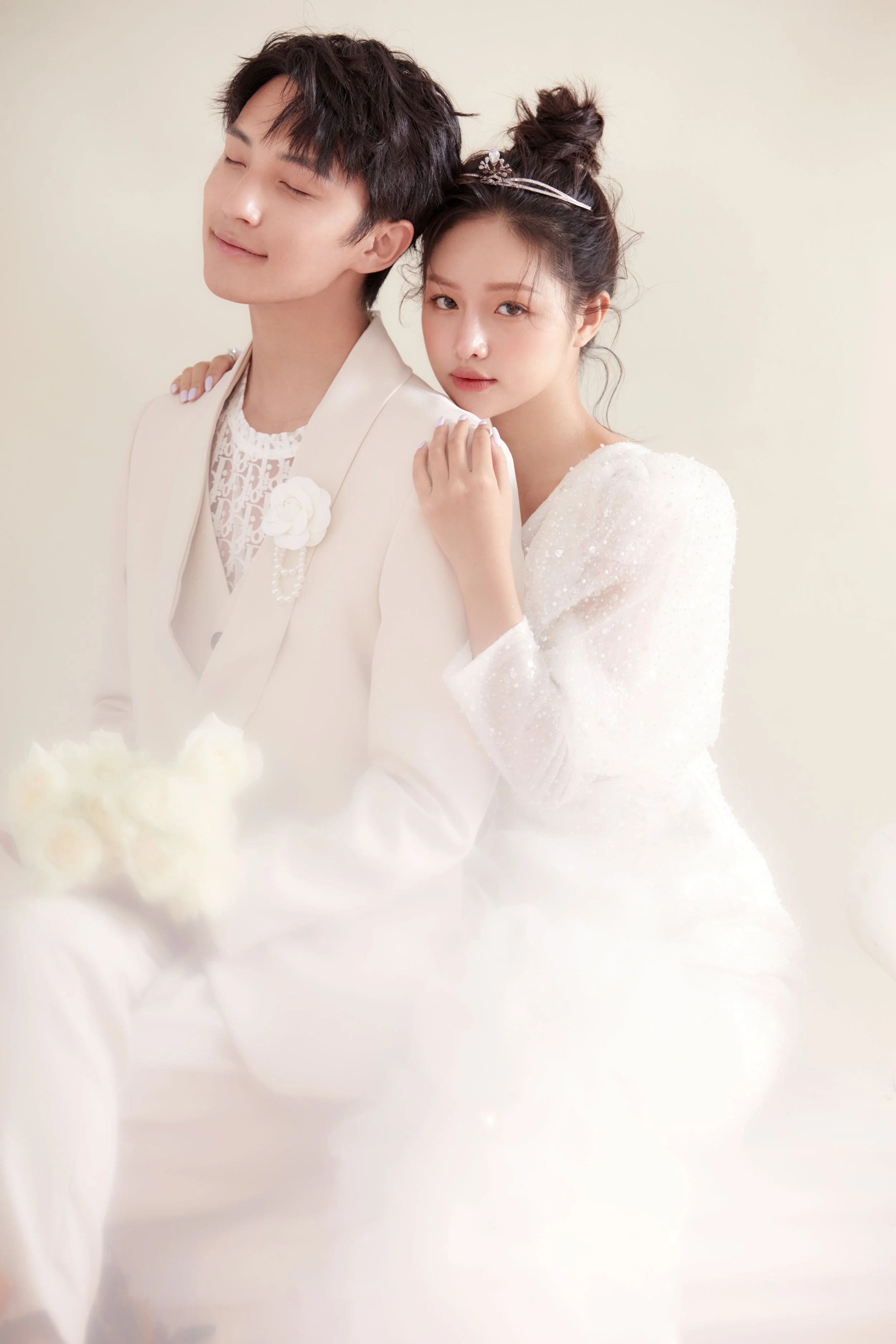 Sweet pre-wedding indoor photoshoot of a young Asian couple in full white