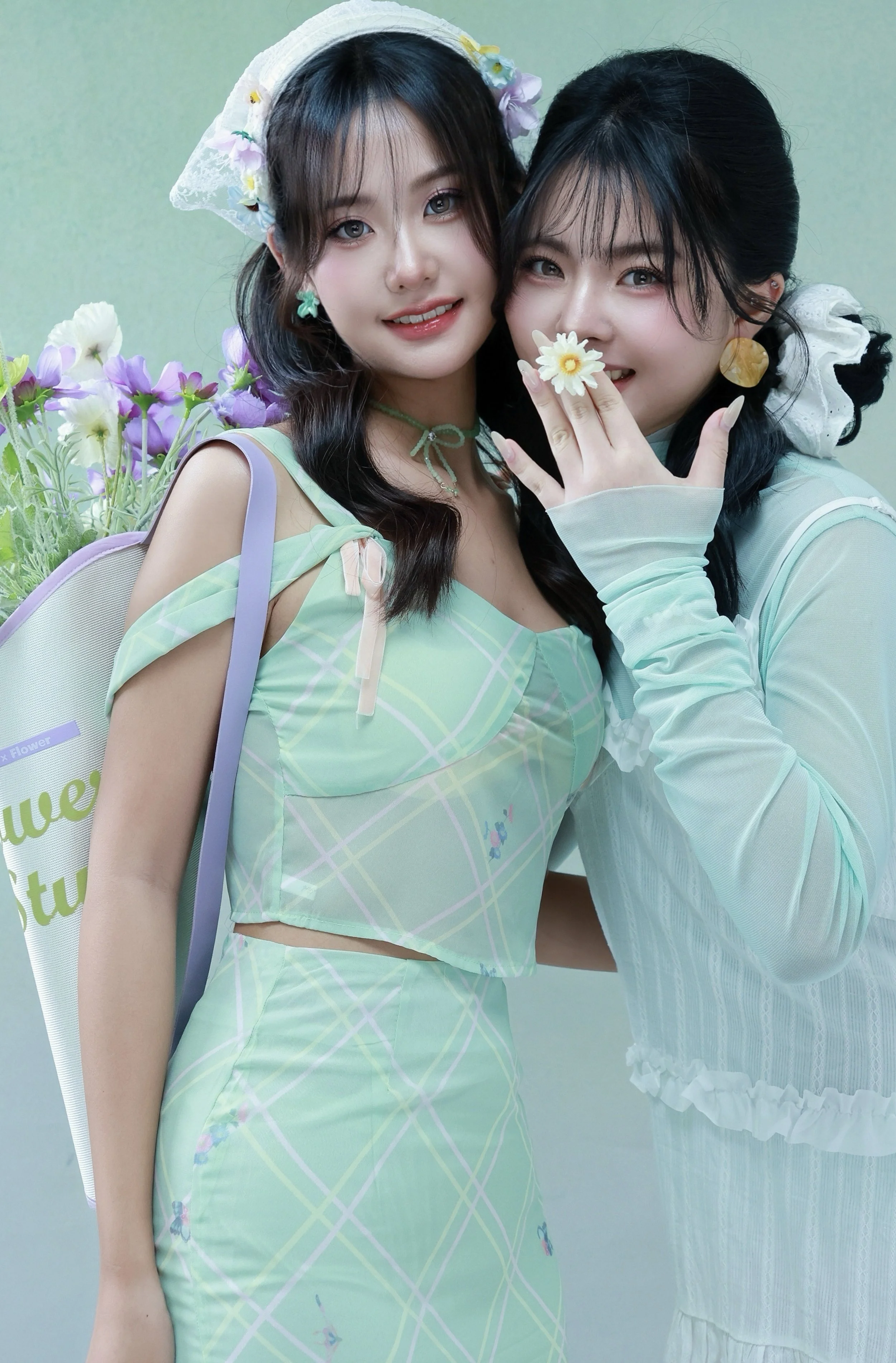 Two friends posing in a mint green floral theme studio