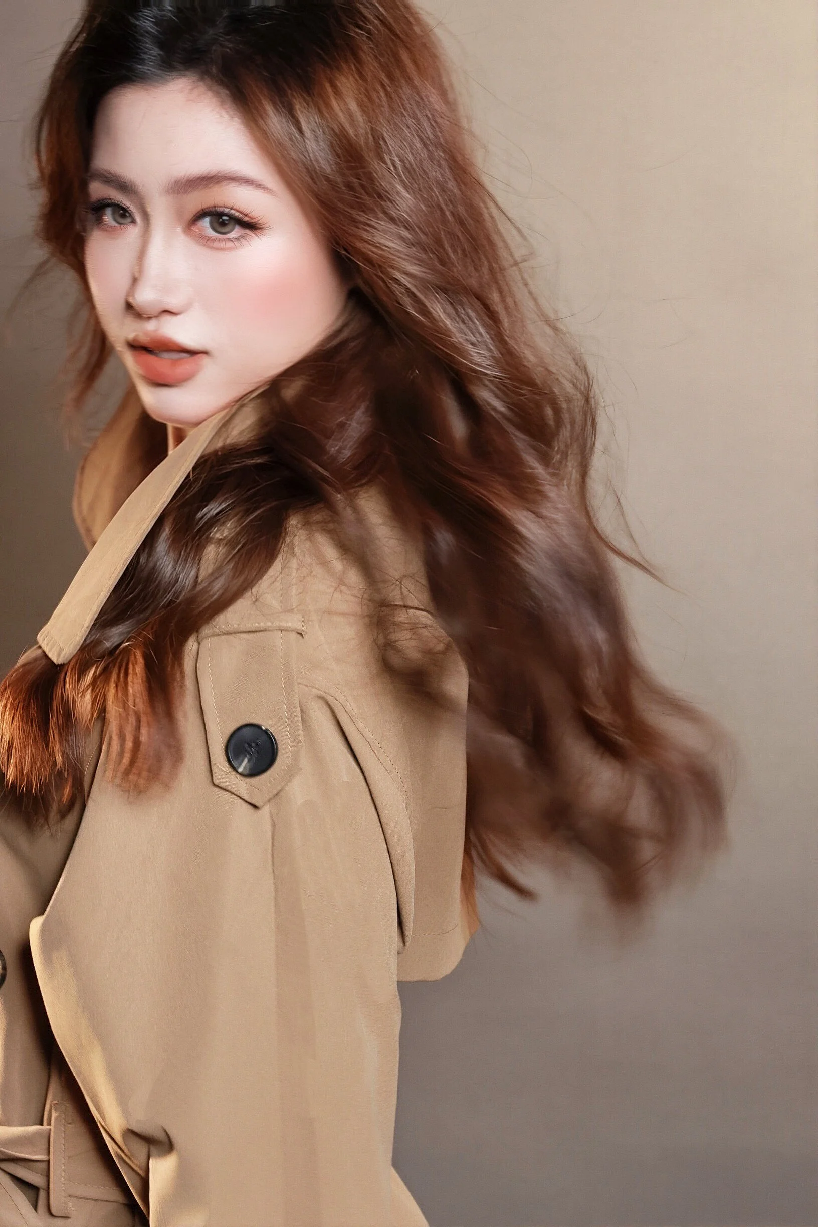 Minimalist portrait of a woman with natural makeup in a brown trench coat