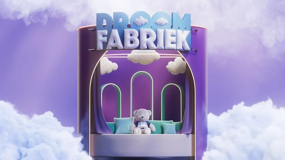 A large purple cloud-themed structure labeled 'Droom Fabriek' with a teddy bear sitting on a turquoise sofa inside, surrounded by clouds and rainbow decorations.