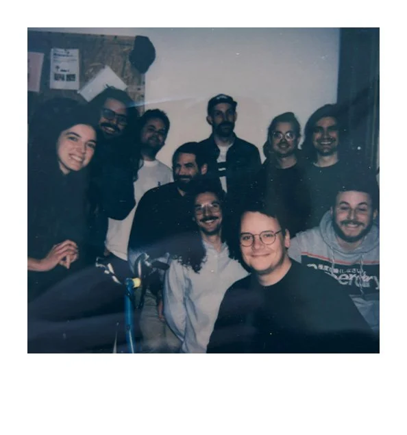 Group of ten people smiling and posing for a photo indoors.
