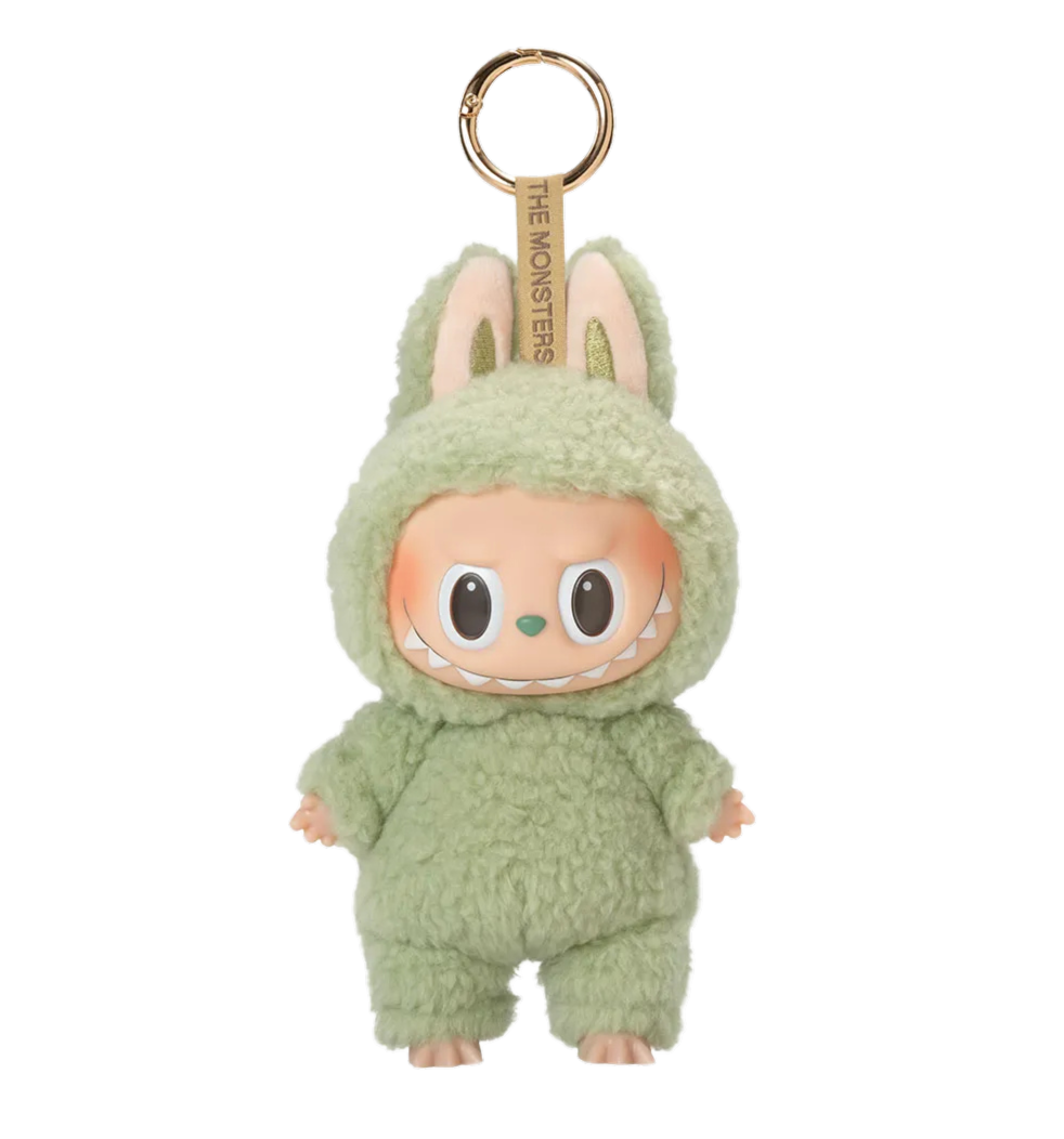 Un porte-clés représentant un personnage de poupée en costume de monstre vert avec des oreilles de lapin, un visage souriant avec des dents pointues.