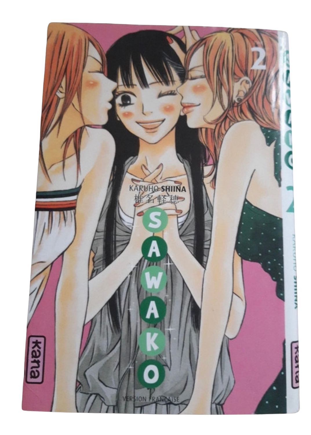 Une illustration de manga représentant trois jeunes femmes, dont une au centre avec les yeux fermés et un sourire,涉及 les deux autres qui l'embrassent sur chaque joue. Le texte indique que c'est un manga de Karuho Shiina intitulé "Sawa Kobo".
