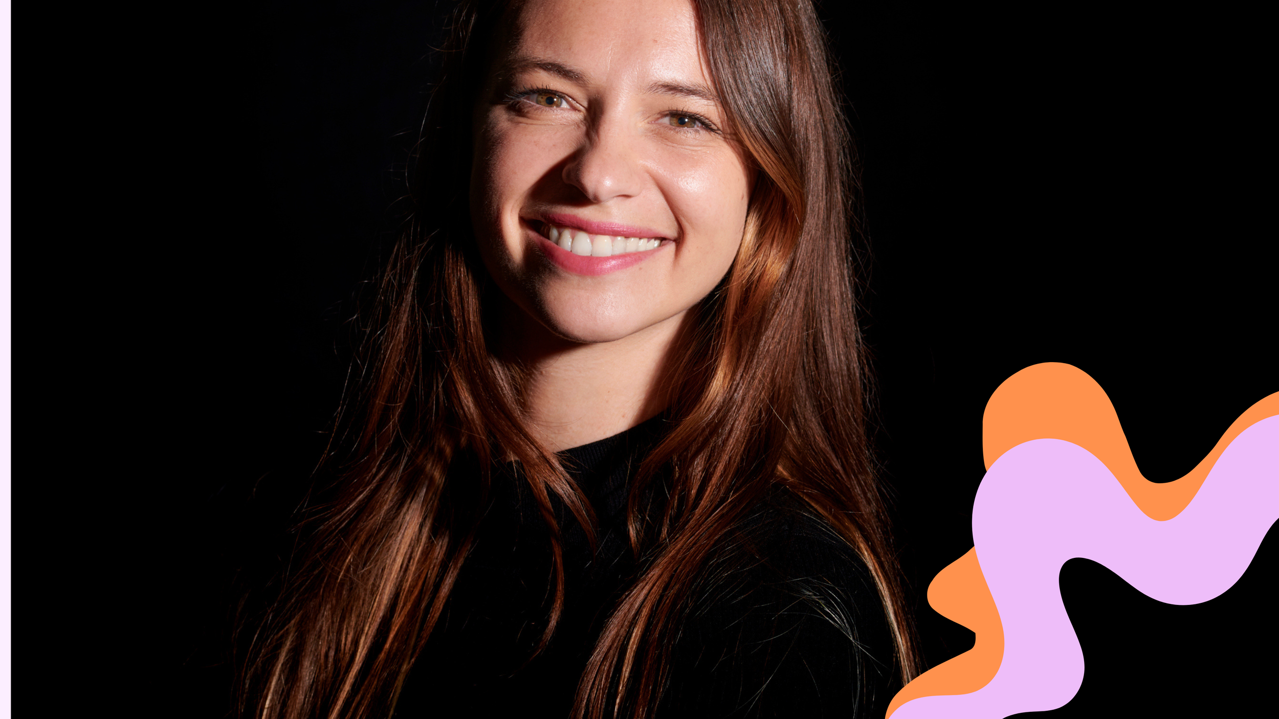 Young woman, called Dana Schröck,  with long brown hair smiling against a black background with colorful abstract shapes in the lower right corner, showing its creativity.