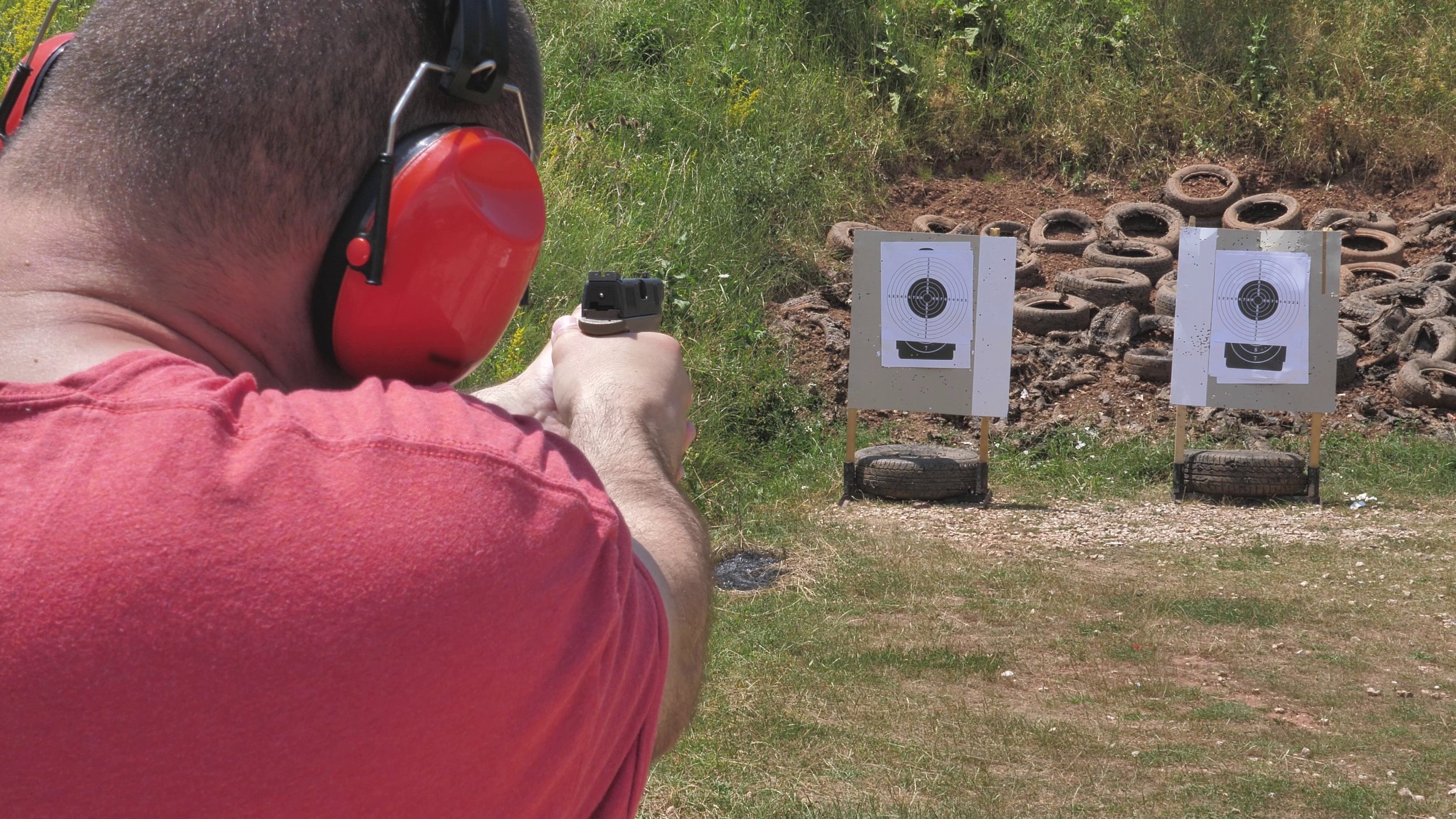 a-shot-from-a-shooters-back-the-man-is-shooting-towards-a-target-with-his-gun-SBI-350075152.jpg