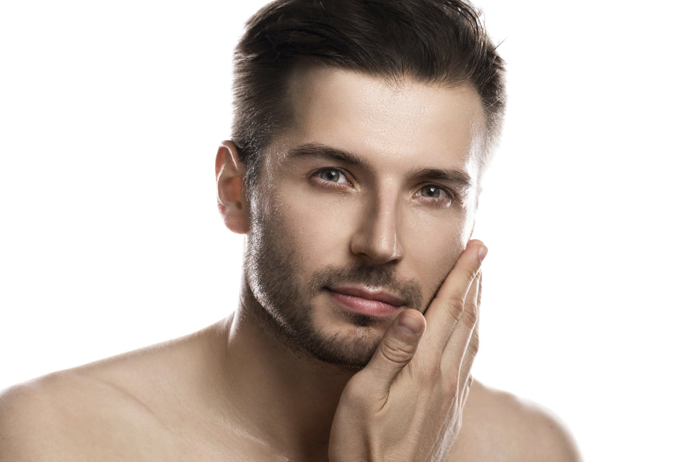 Male model with clear, defined features touching his face, representing dermal filler results.