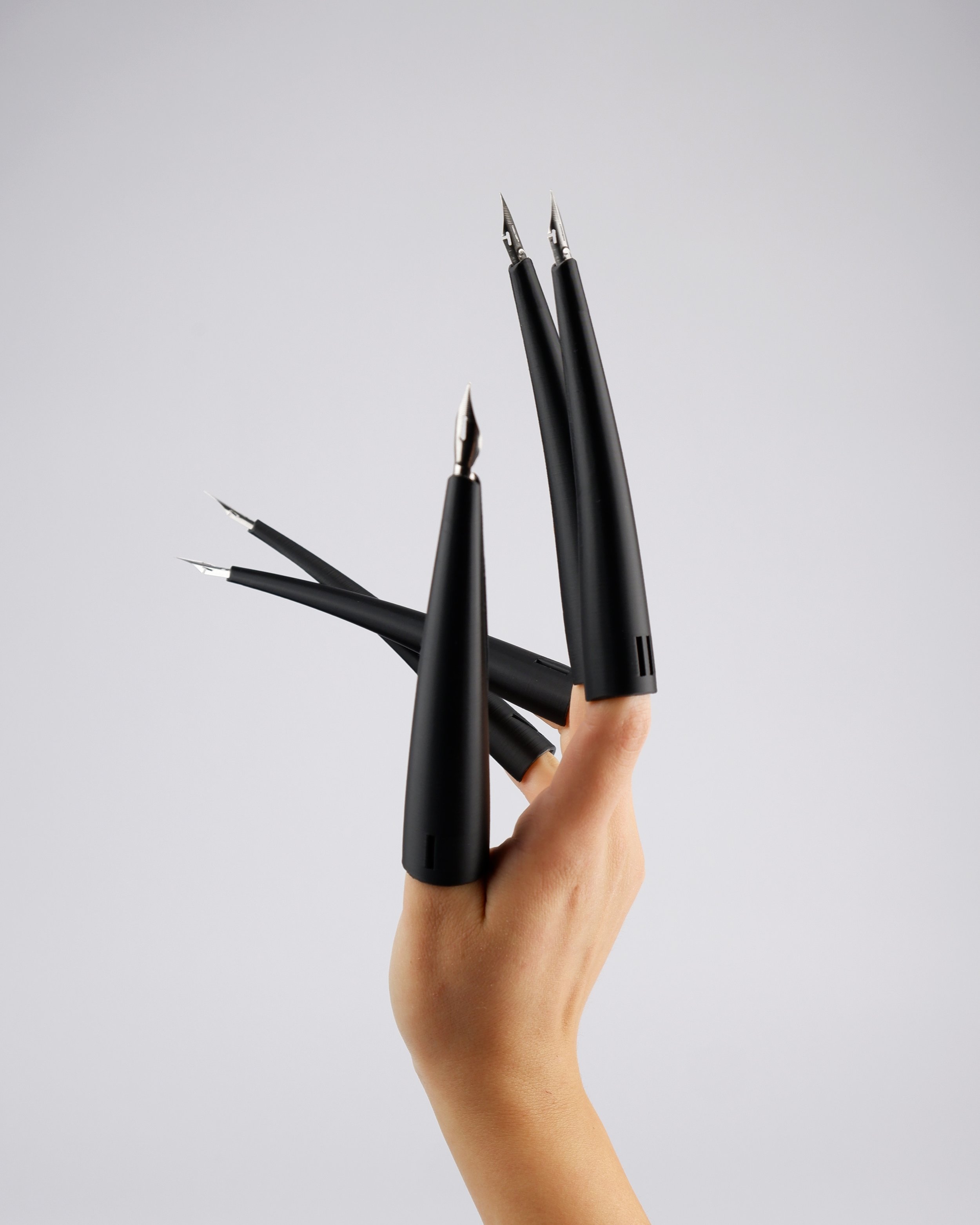 Claws
Spinoni Luca

Protesi in PLA nero 3D printed di 12 cm l'uno, numrate da I a V e ispirate ai zhijiatao (指甲套) cinesi. Le dita diventano strumenti indipendenti permettendo di scrivere a pi&ugrave; dita e a spessori differenti. #about #aboutwriting