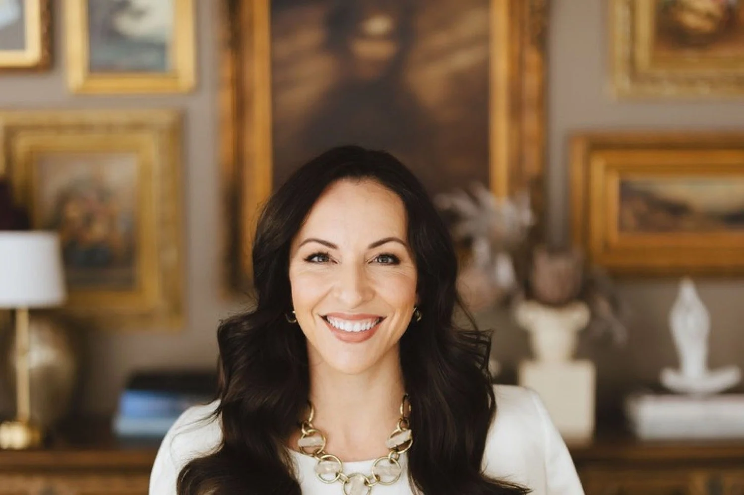 Dr. Brittany Dickinson, Chicago cosmetic dentist, smiling warmly at desk in her Lakeview practice.